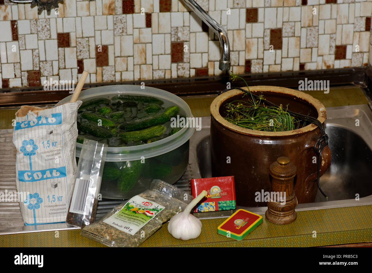 Grüne Gurken in Gläsern auf Küchenarbeitsplatte Stockfoto