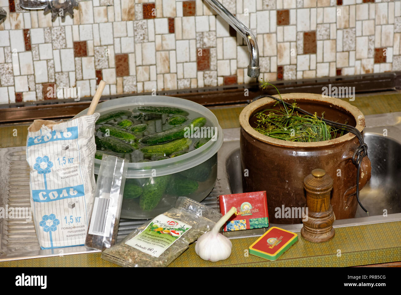 Grüne Gurken in Gläsern auf Küchenarbeitsplatte Stockfoto