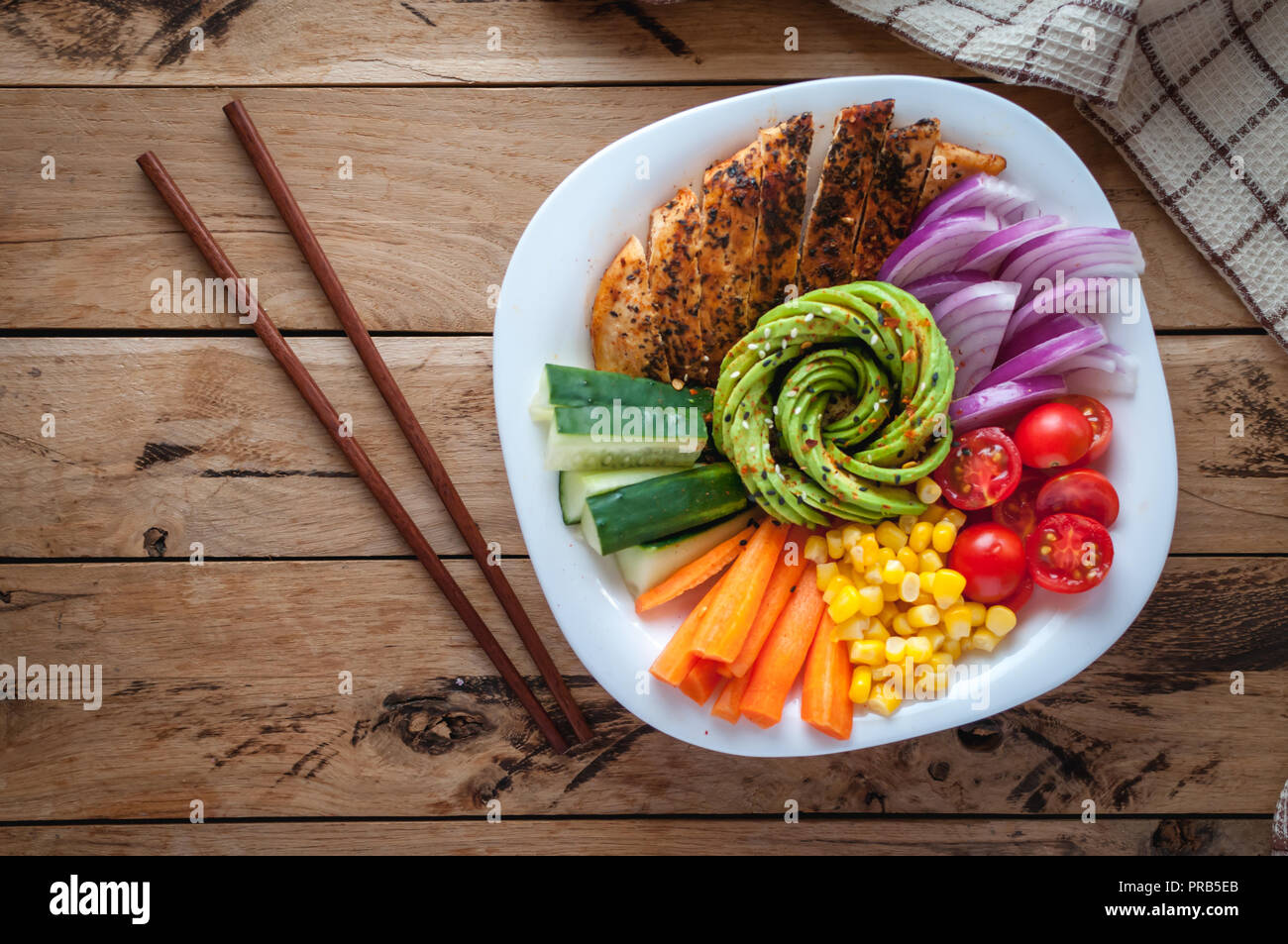 Buddha Schüssel mit Hähnchen und Gemüse auf hölzernen Hintergrund, Ansicht von oben Stockfoto