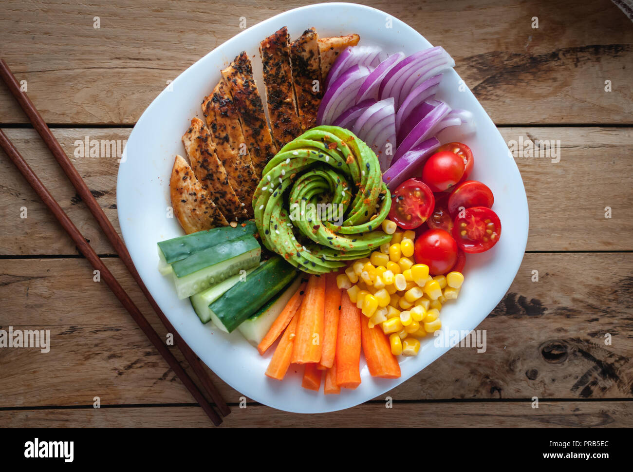 Buddha Schüssel mit Hähnchen und Gemüse auf hölzernen Hintergrund, Ansicht von oben Stockfoto