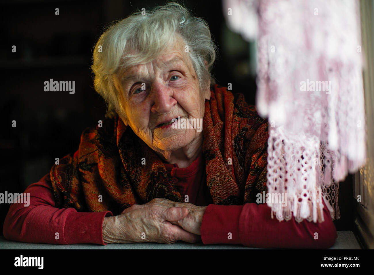 Porträt der alten Frau am Tisch sitzen. Stockfoto