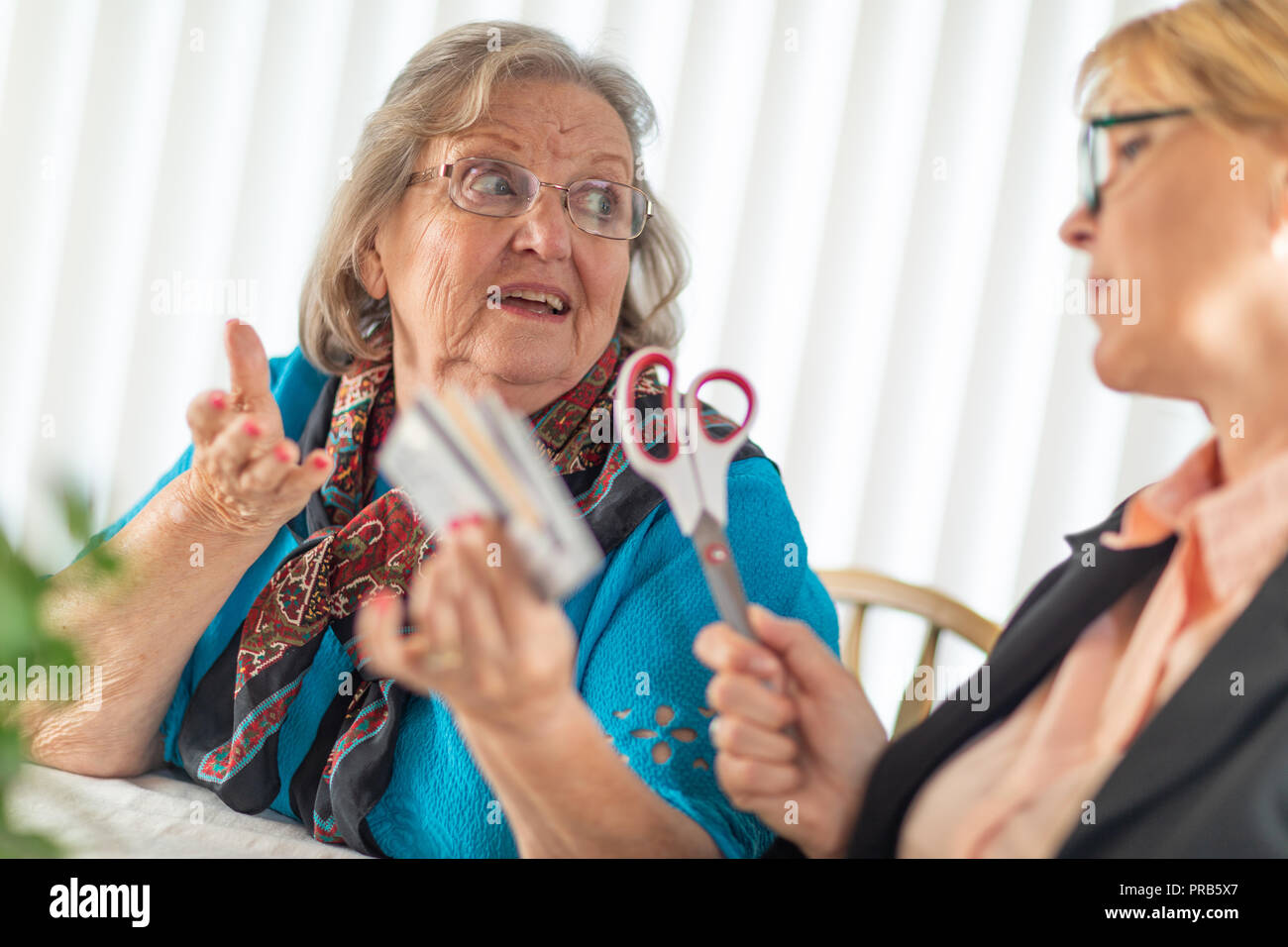 Finanzielle Berater Übergabe Schere zu den älteren Dame Holding Kreditkarten. Stockfoto