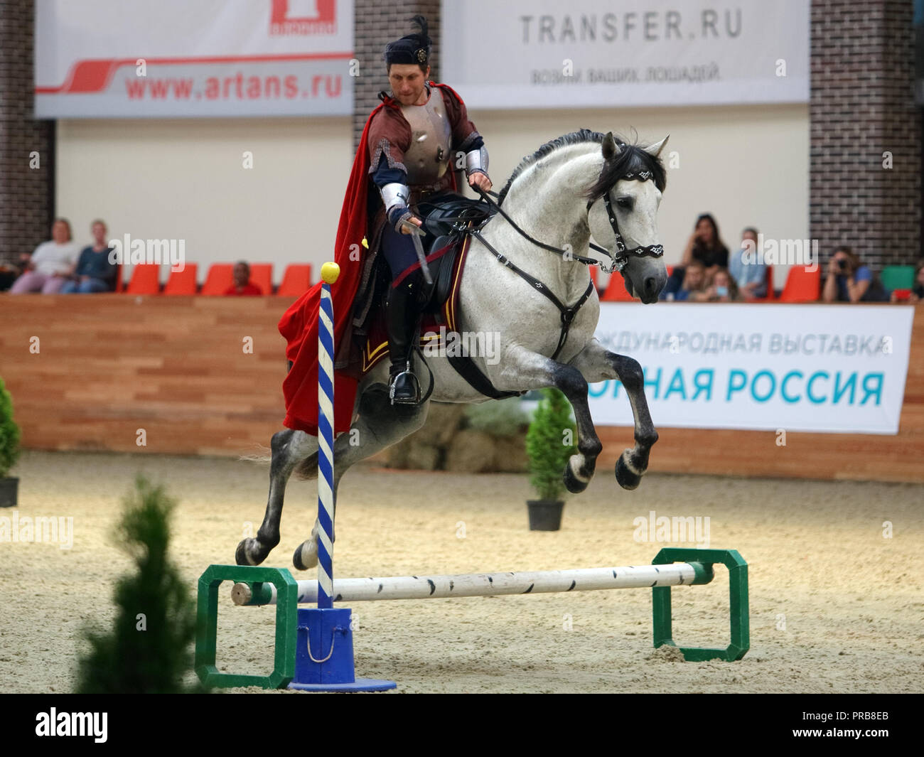Krieger in mittelalterlichen Kleidern ist das Schneiden der Apple mit dem Schwert beim Reiten Stockfoto