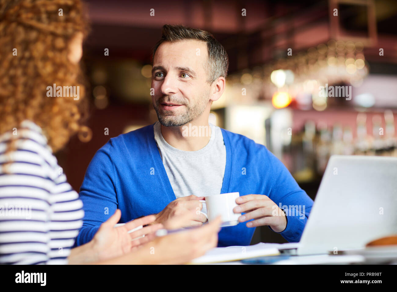 Inhalt gut aussehender Geschäftsmann mit Stoppeln Kaffee trinken und Frau während der informellen Treffen im Cafe Stockfoto