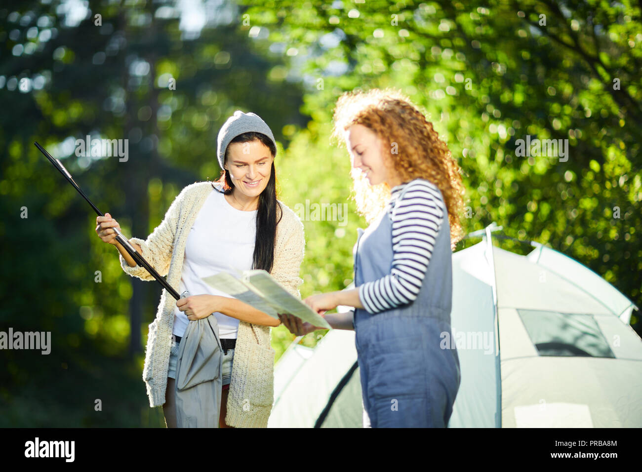 Zwei junge weibliche Camper Lesung über die Beilegung camp Zelt und Vorbereitung bars installieren Stockfoto