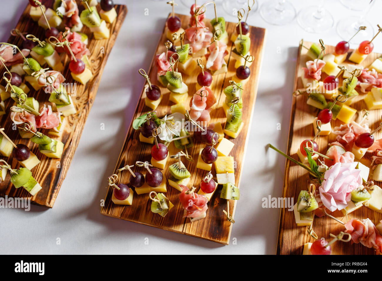 Das Buffet an der Rezeption. Sortiment von Häppchen auf Holzbrett. Bankettservice. catering Essen, Snacks mit Käse, Schinken, Schinken und Obst Stockfoto