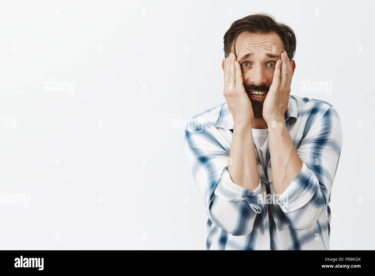Was habe ich getan. Portrait von schockiert und nervösen verzweifelten erwachsenen Mann, bückte sich und halten Palmen auf Gesicht und starrte vor Schreck und Angst an Kamera, Angstgefühle zu verlieren Familie Ursache der Herrin Stockfoto