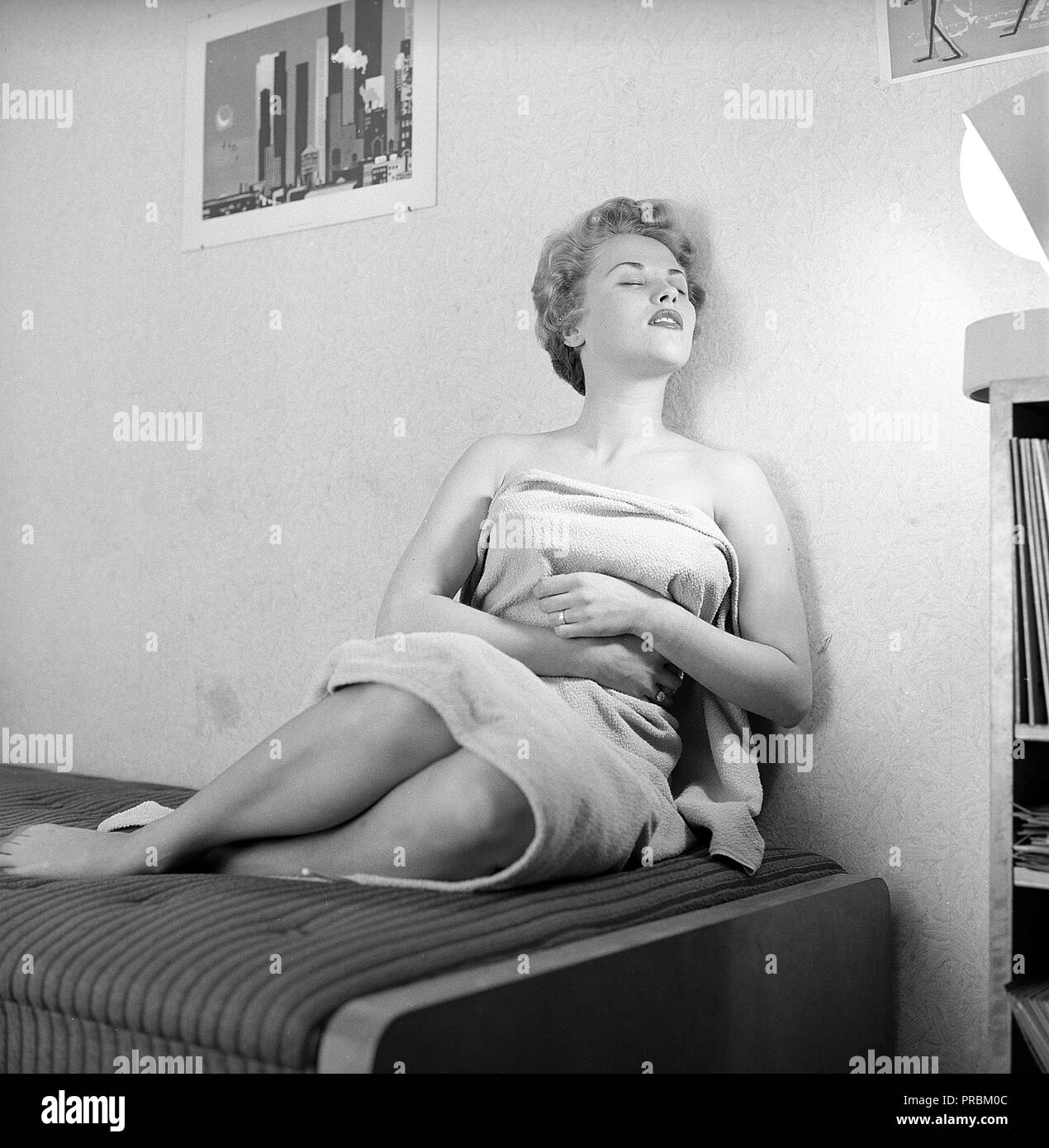 Beauty Care in den 1950er Jahren. Eine junge Frau wird zu bräunen, durch die künstliche Sonnenlicht aus dem Hause bräunende Höhensonne. Ein Gerät, das ein tan gab und war manchmal zur Behandlung von Krankheiten. Bild Sänger Bibi Johns geboren 1929. Schweden 1954. Ref 2666 Stockfoto