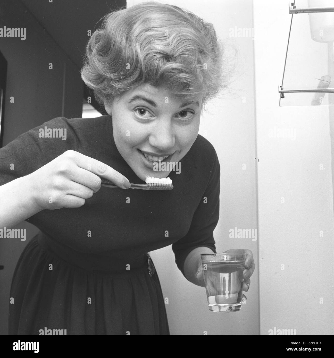 Frau in den 1950er Jahren. Eine junge Frau ist, bürsten Sie teath. Schweden 1957 Stockfoto