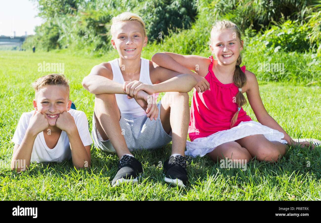 Lachende Kinder im Freien spielen funning auf Gras im Sommer Tag Stockfoto