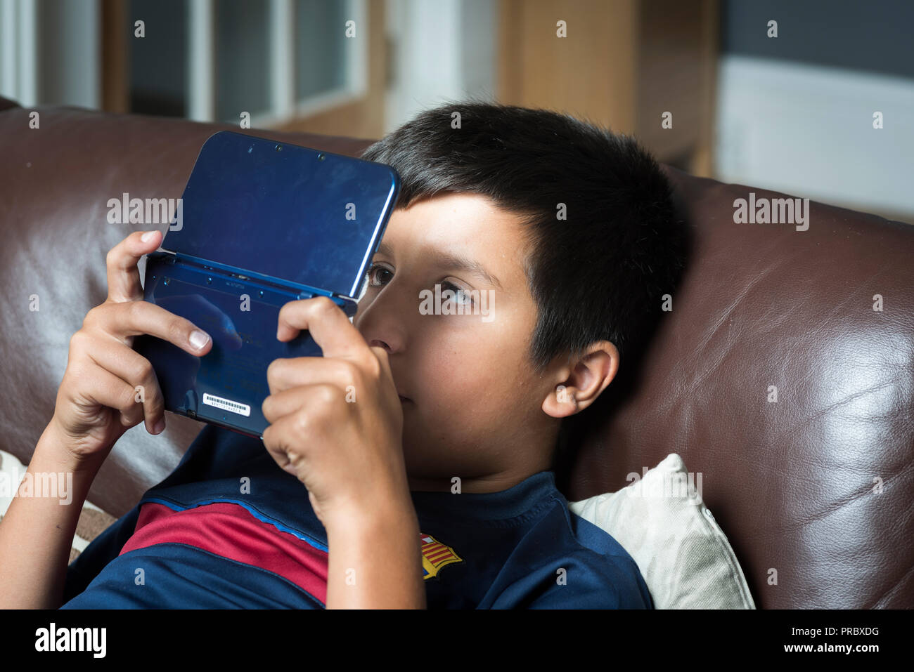 Okuläre Abweichung. Extreme Gaming und elektronische Gadgets verwenden könnten Kinder cross-eyed-boy spielt computer spiel auf tragbare Spielekonsole Stockfoto