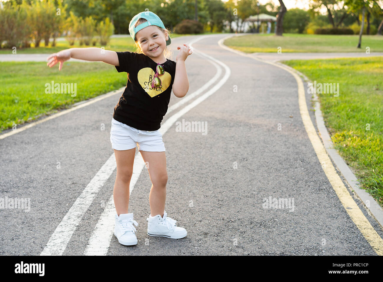 Fashion kid Konzept - Porträt der elegante kleine süße Mädchen Kind trägt eine Kappe im Freien in der Stadt. Stockfoto