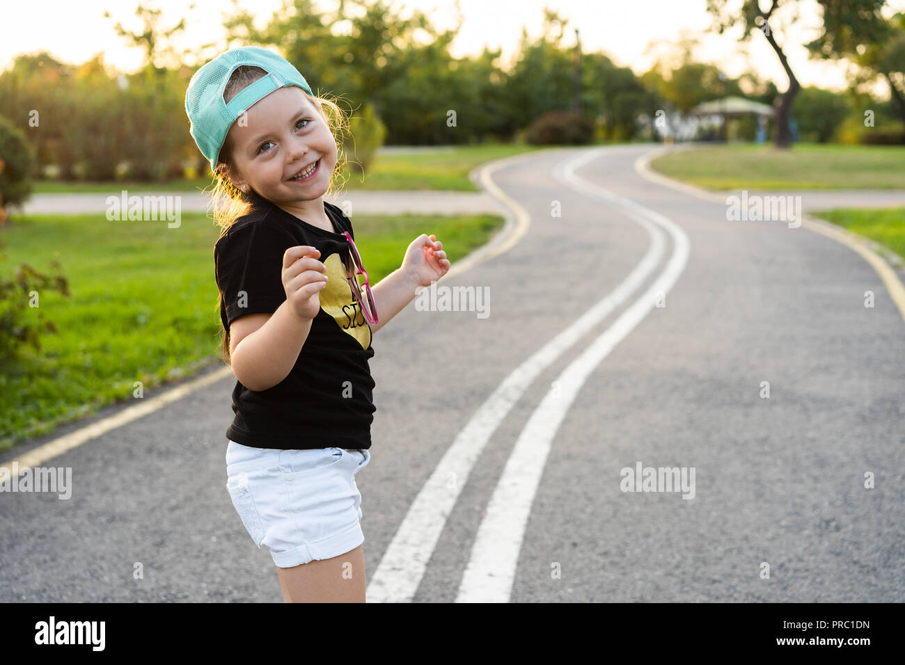 Fashion kid Konzept - Porträt der elegante kleine süße Mädchen Kind trägt eine Kappe im Freien in der Stadt. Stockfoto