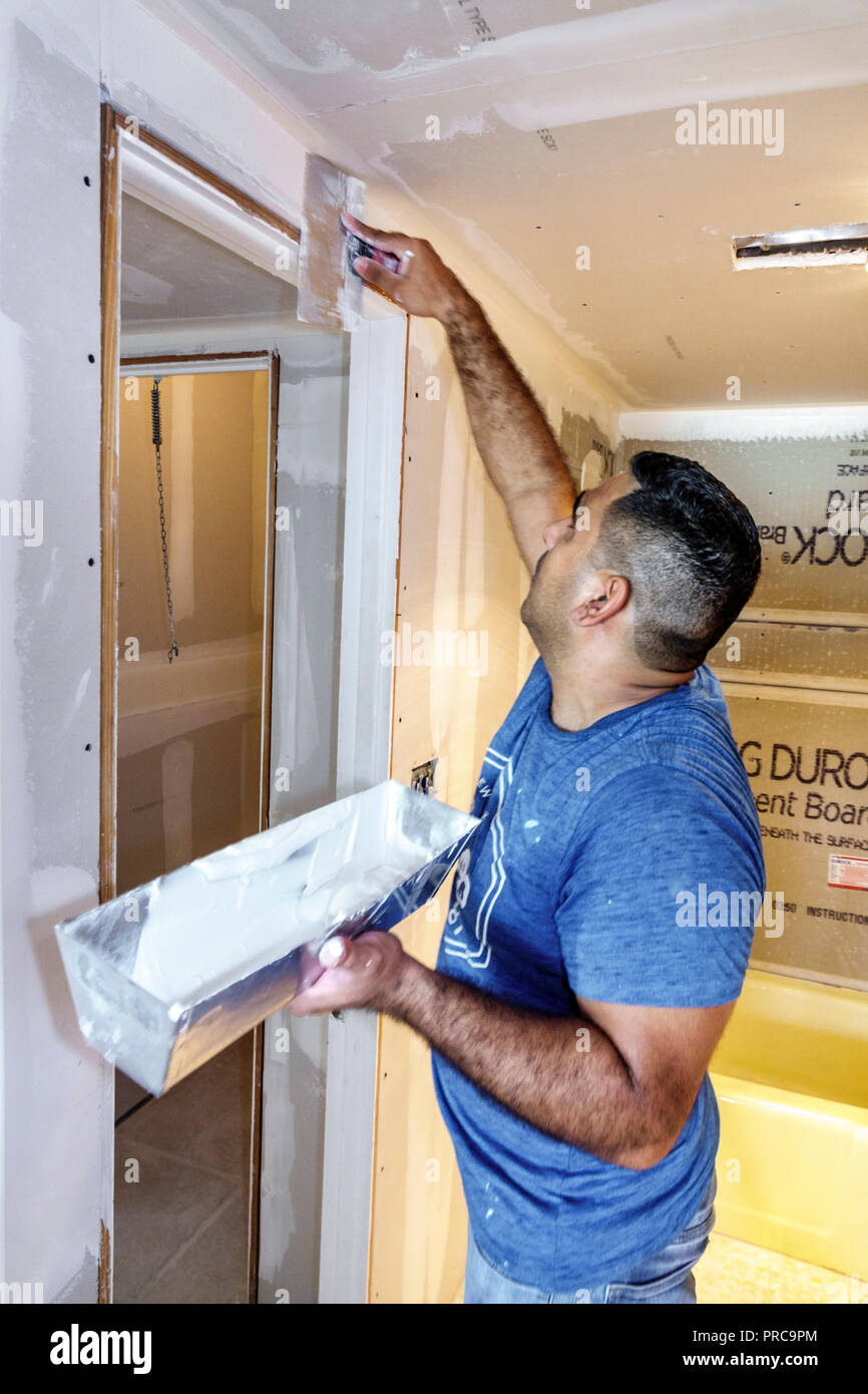 Miami Beach Florida, Auftragnehmer, Renovierung, Reparatur, Trockenbau, hispanischer Mann Männer männlich, arbeiten, Verbreiten Gipsmasse Kitt Schaber Messer, FL180630062 Stockfoto