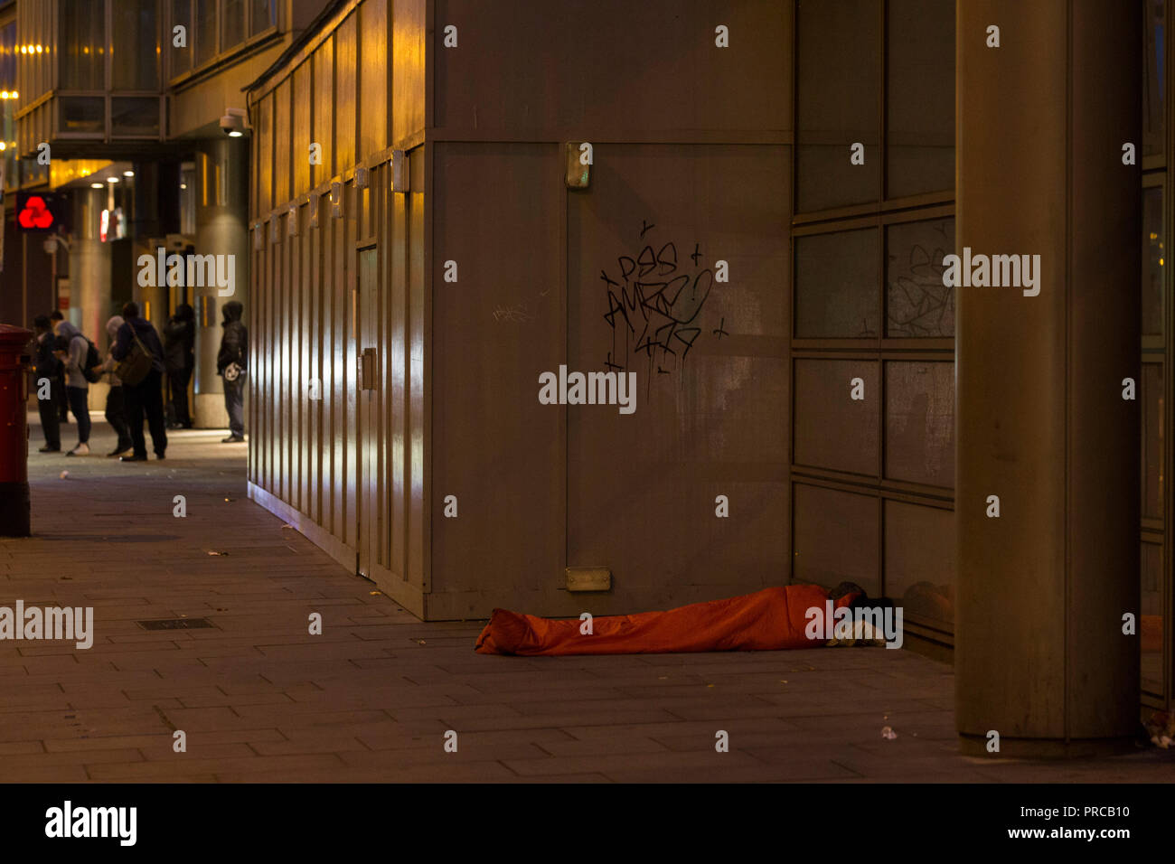 Obdachlose Person liegt auf dem Bürgersteig in der Liverpool Street im Zentrum von London, Großbritannien Stockfoto