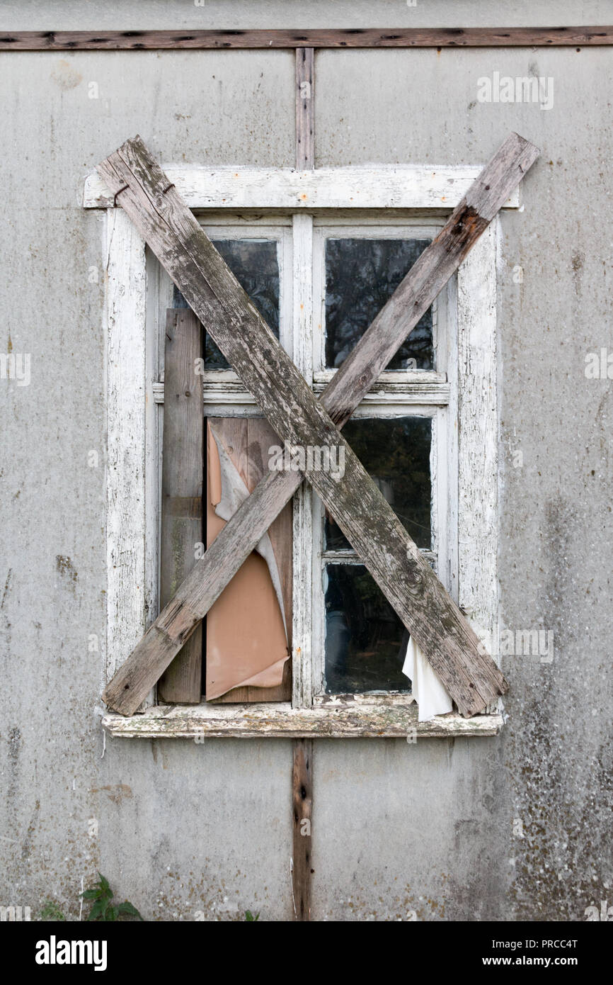 Blick auf ein altes Fenster mit Brettern vernagelt. Stockfoto