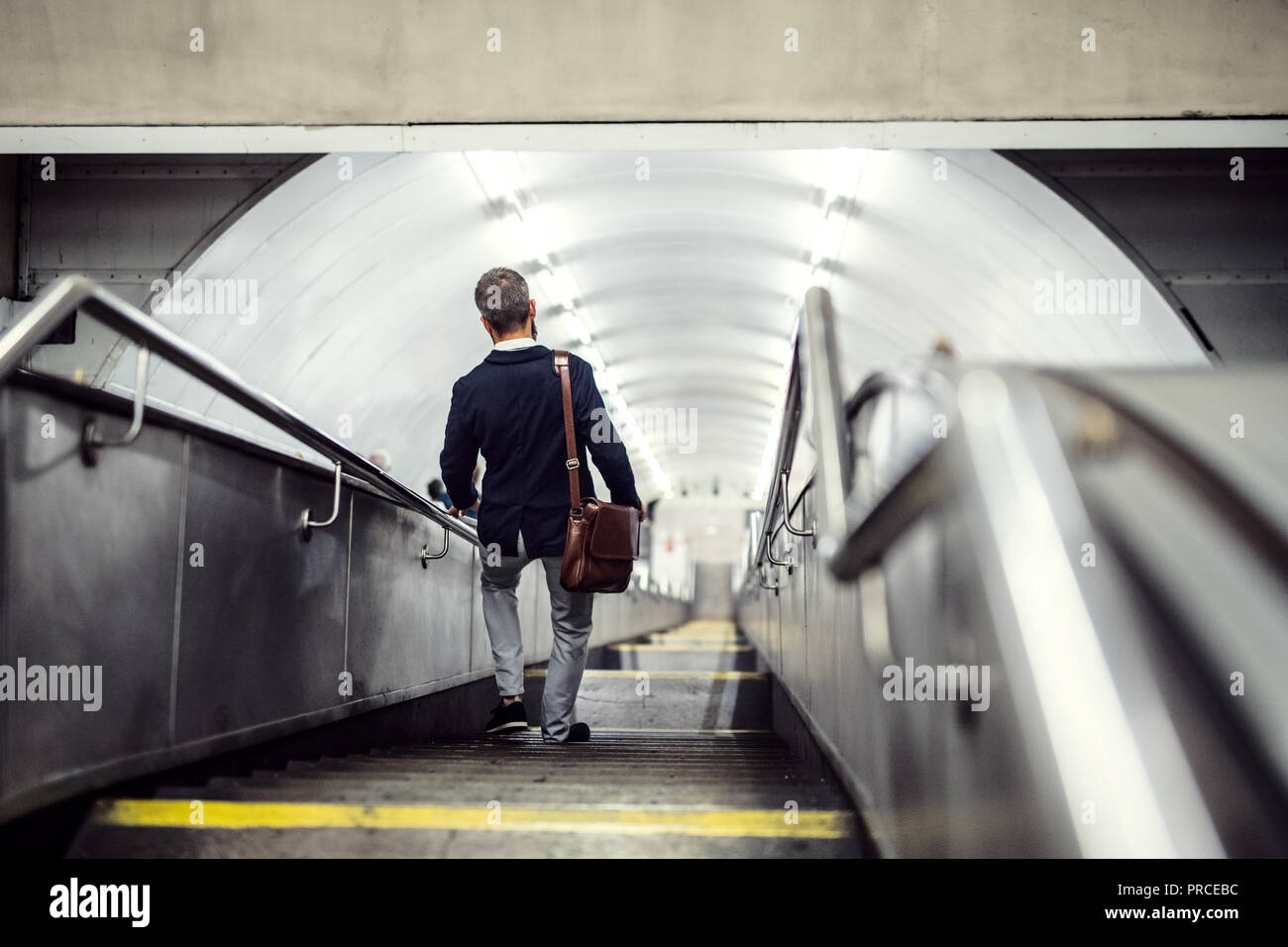 Ansicht der Rückseite des hipster Geschäftsmann zu Fuß die Treppen hinunter in der Nähe der U-Bahn, unterwegs zu arbeiten. Stockfoto