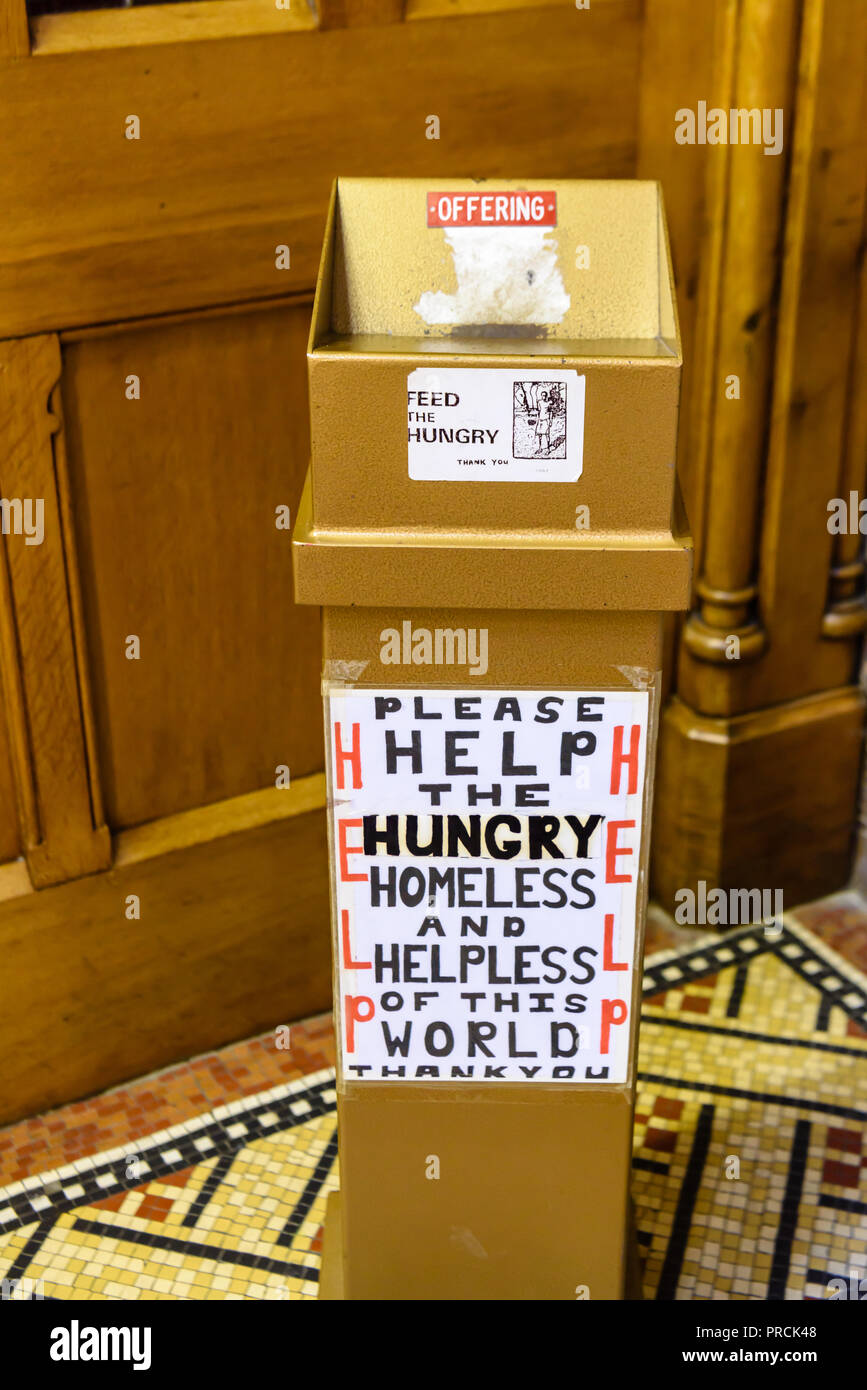 Collection Box in einer Kirche bittet um Spenden für die Hungernden, Heimatlosen und hilflos dieser Welt. Stockfoto
