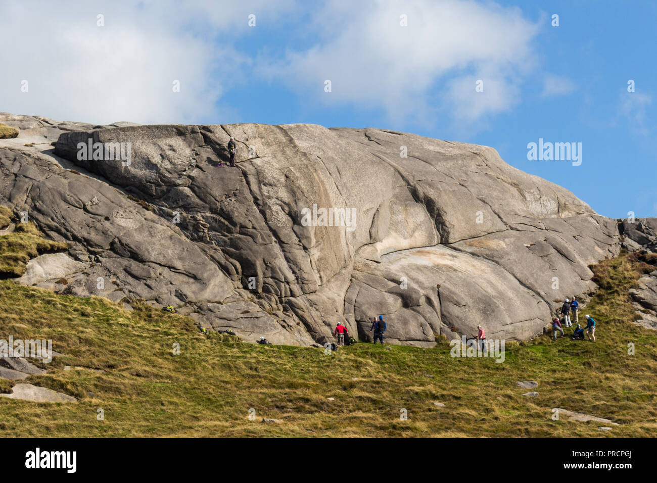 Ein Lernen in der Gruppe klettern auf einem Felsen auf Henne Berg, Mourne Mountains, N. Irland zu rocken. Stockfoto