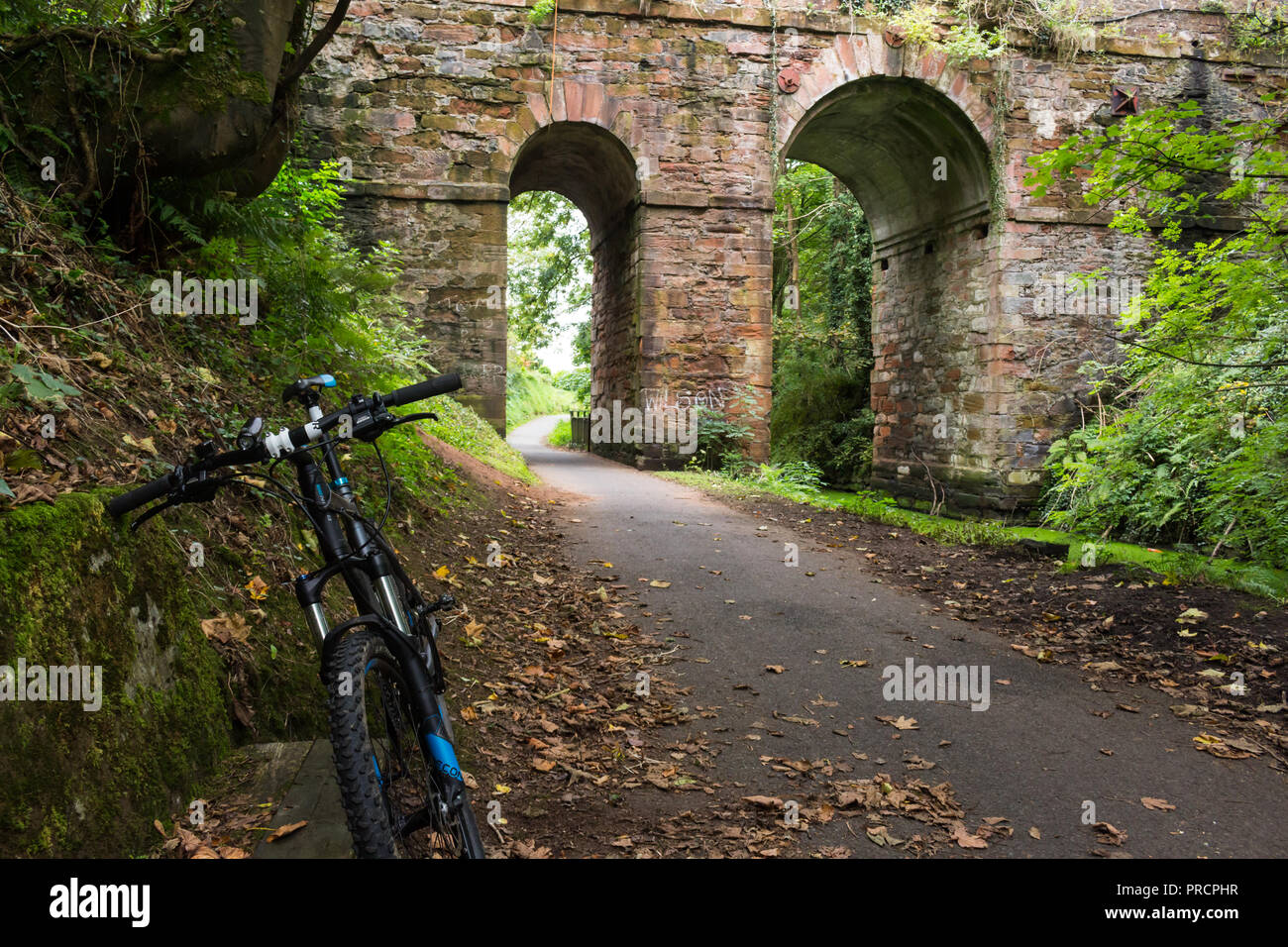 Ein Fahrrad geparkt auf dem Lagan Leinpfad, zwischen Lisburn und Belfast bei einer Brücke aus Stein, während die Radfahrer nimmt einen Rest. Stockfoto