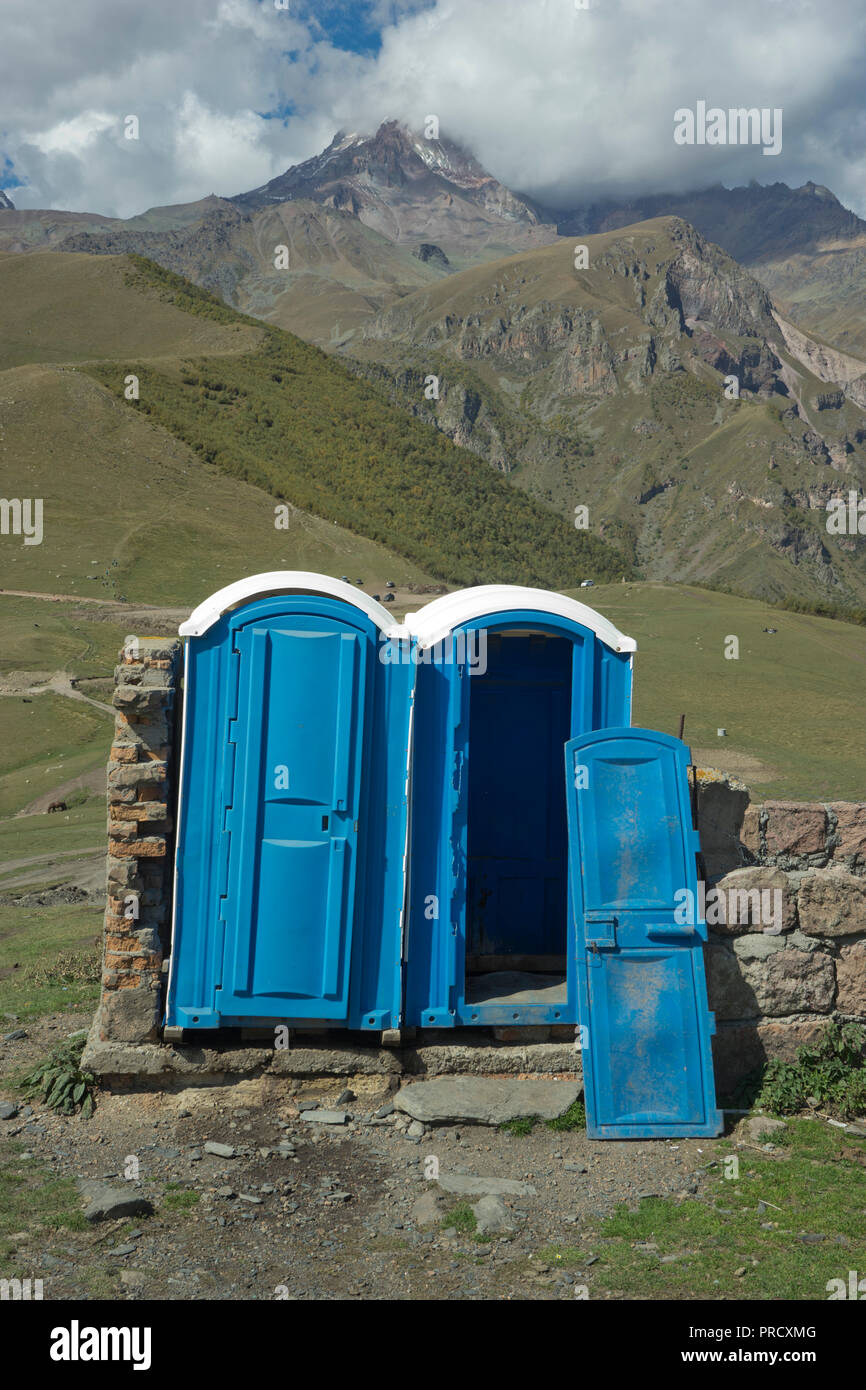 Mobile Toiletten in der Nähe der Kirche der Heiligen Dreifaltigkeit Gergeti durch den Fluss Chkheri, unter dem Berg Kazbegi liegt auf einer Höhe von 2170 Metern in den Kaukasus, Georgi Stockfoto