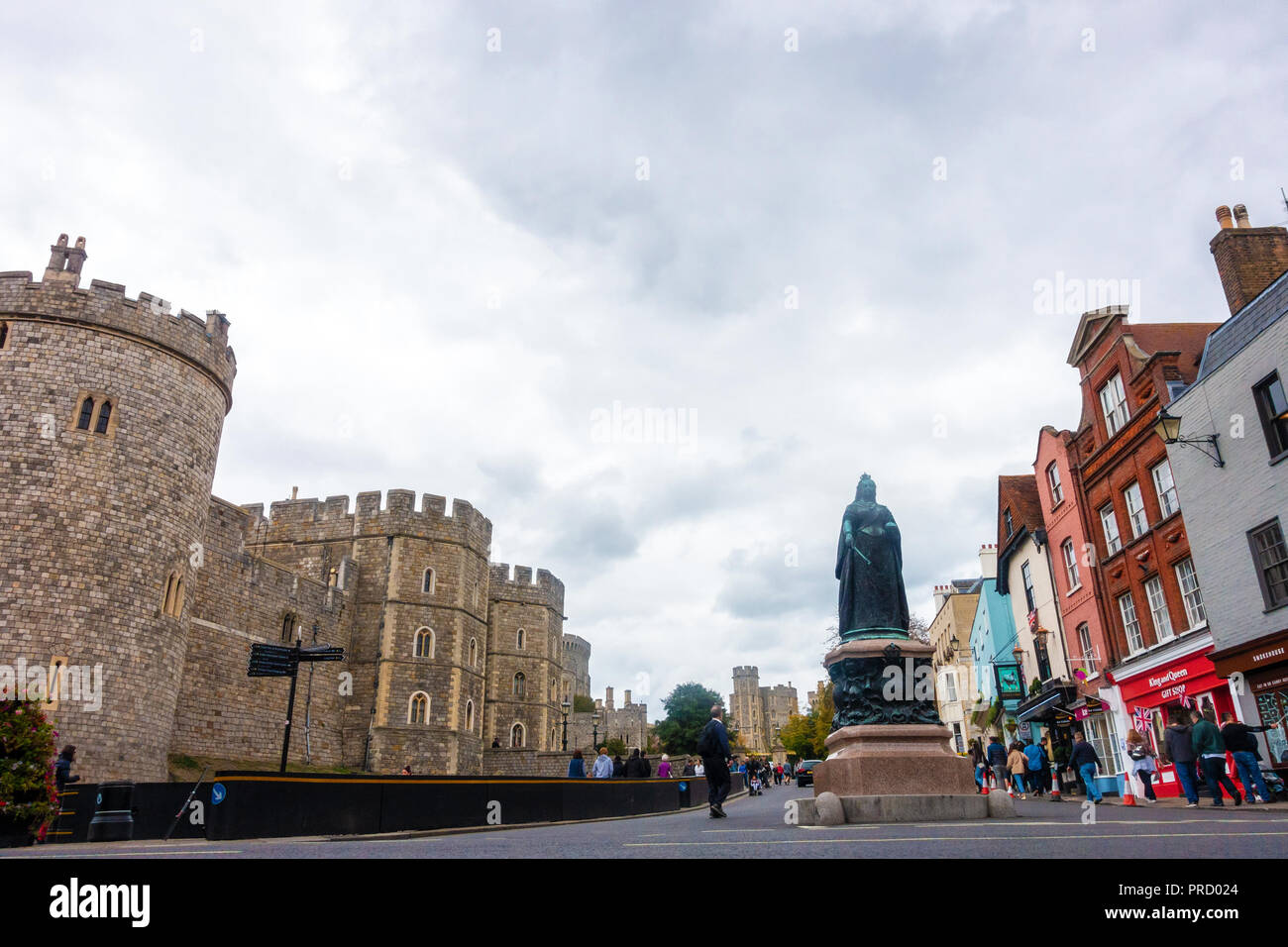 Ein Blick auf Windsor Castle und die Skulptur von Königin Victoria, die außerhalb auf einem kalten, grauen bedeckt und trübe Tag in Windsor, UK steht. Stockfoto