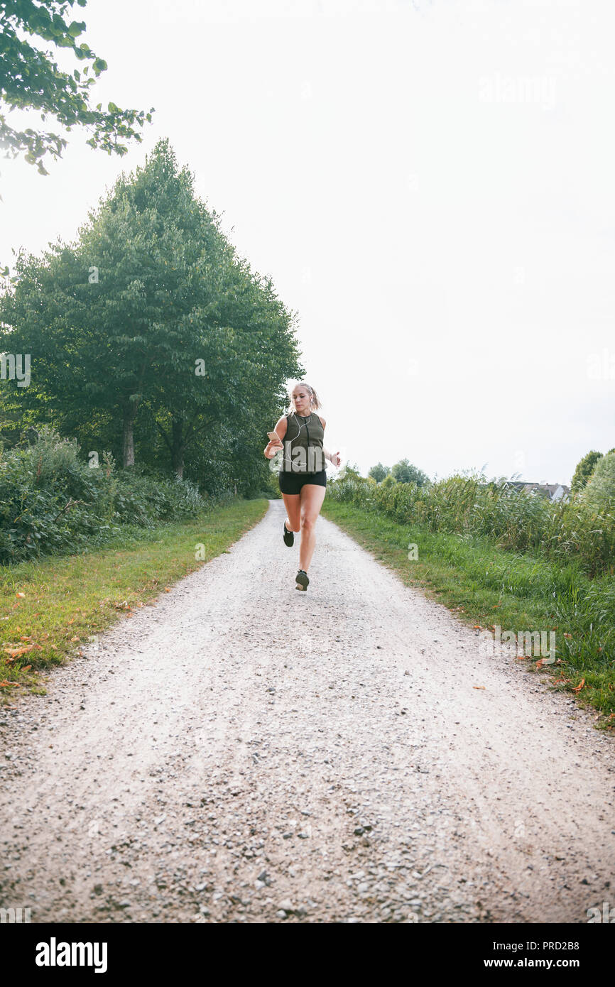 Blond sport Frau joggt in Park Stockfoto