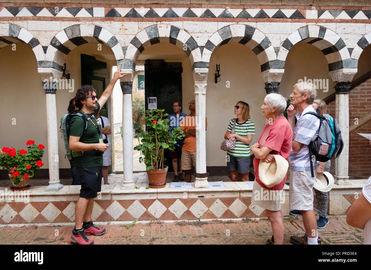 Italien Tourismus - Touristen auf einer Führung durch die mittelalterliche Abtei der Heiligen Dreifaltigkeit und St. Mustiola, Torri, Toskana Italien Europa Stockfoto