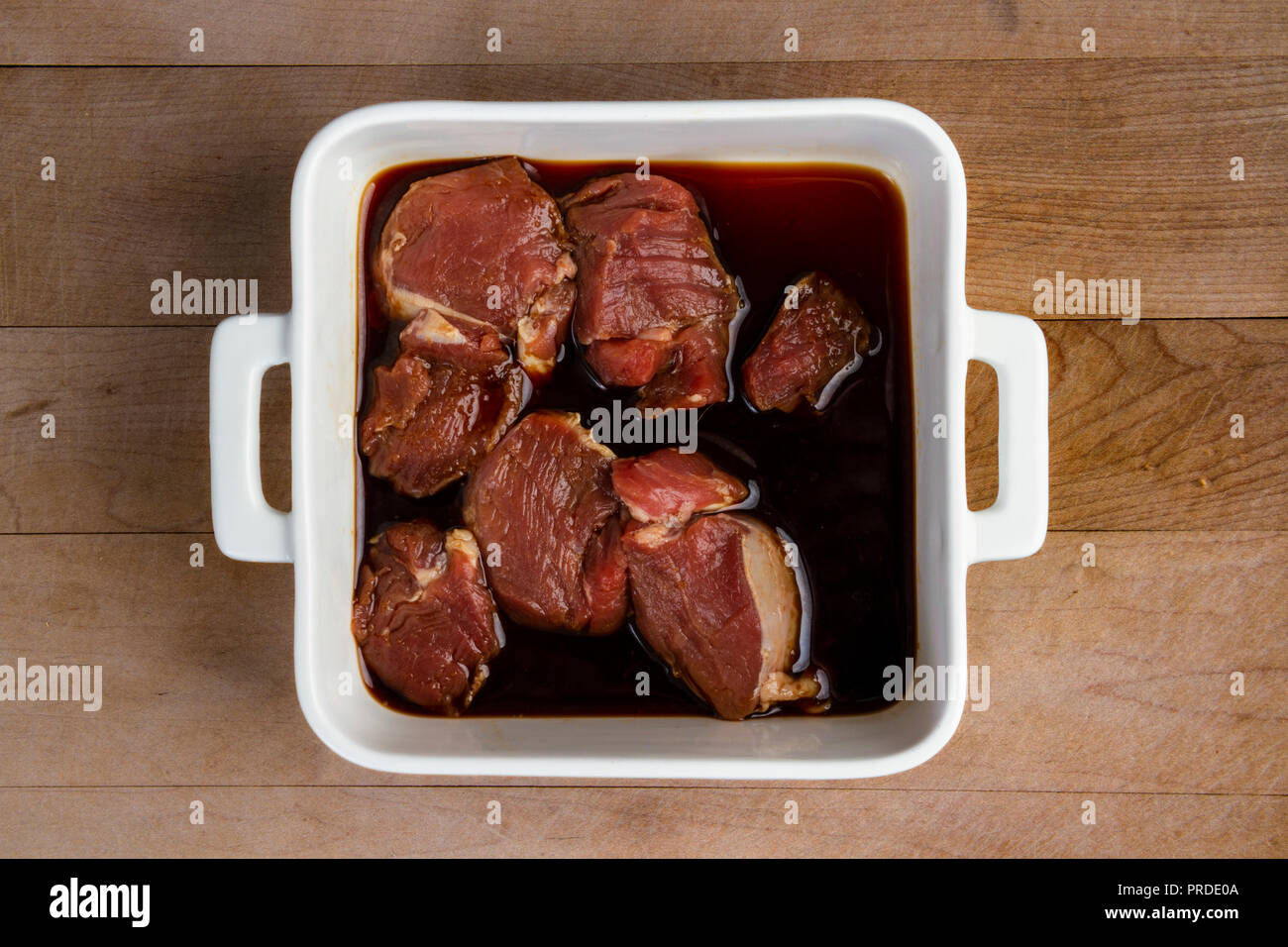 Nicht gegartem Schweinefleisch filet Schichten Marinieren nur in einem weißen Teller Stockfoto