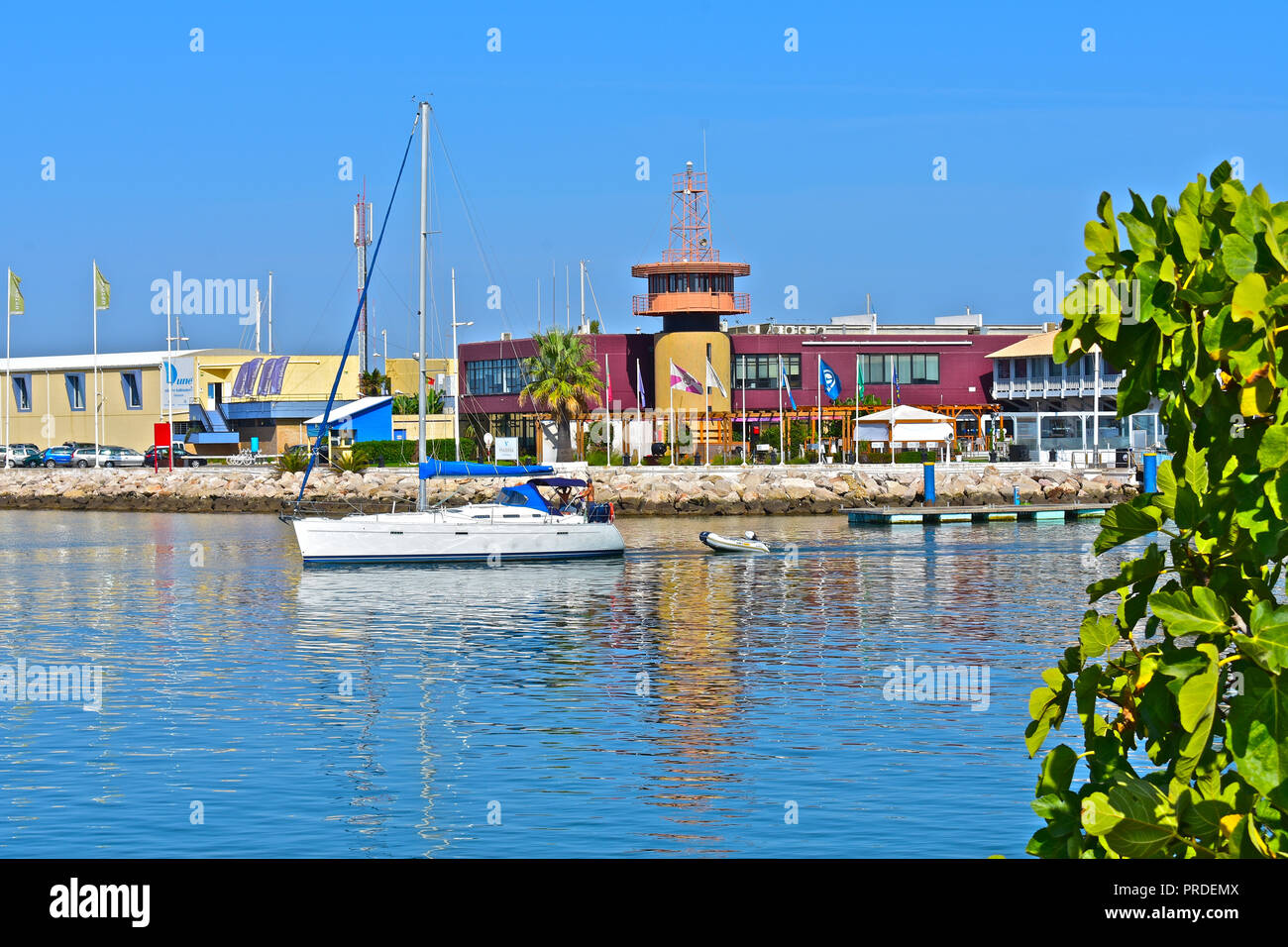 Der scheidende Yacht übergibt den Leuchtturm und Turm am Eingang zum Yachthafen von Vilamoura, Algarve, Portugal Stockfoto