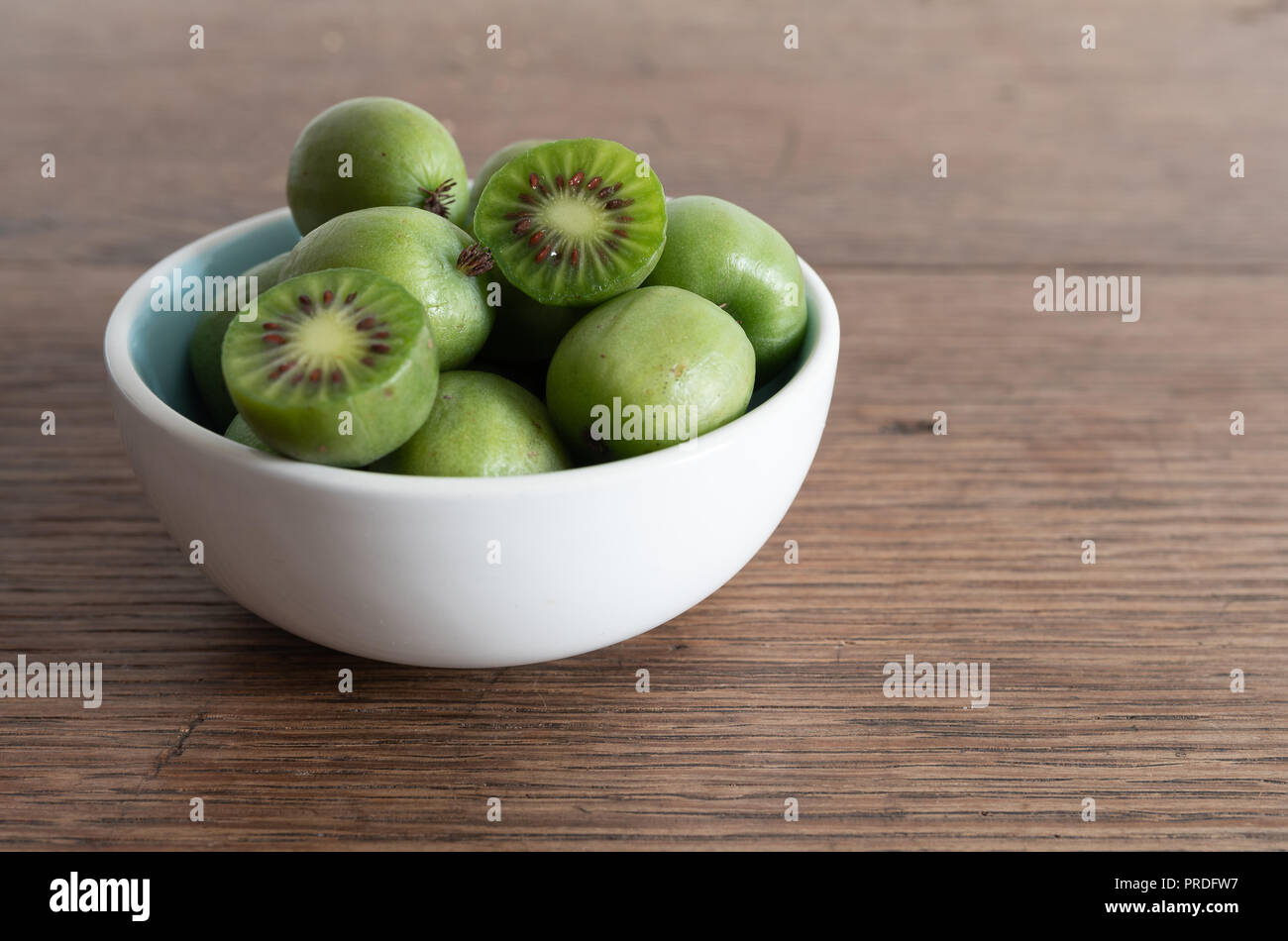 Hardy Kiwis oder kiwi Berry in Keramik Schüssel auf dem Tisch Stockfoto