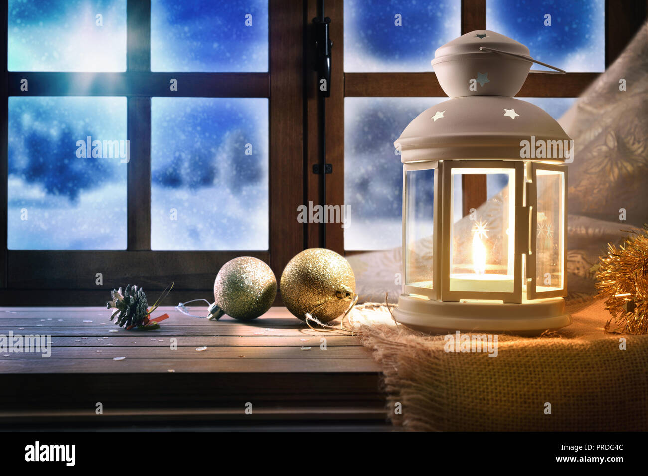 Lampe mit Weihnachten Dekoration auf einem Tisch in der Nähe eines Fensters mit schneebedeckten Hintergrund in der Nacht. Horizontale Zusammensetzung Stockfoto Lampe mit Weihnachten Dekoration auf einem Tisch in der Nähe eines Fensters mit schneebedeckten Hintergrund in der Nacht. Horizontale Zusammensetzung Stockfoto