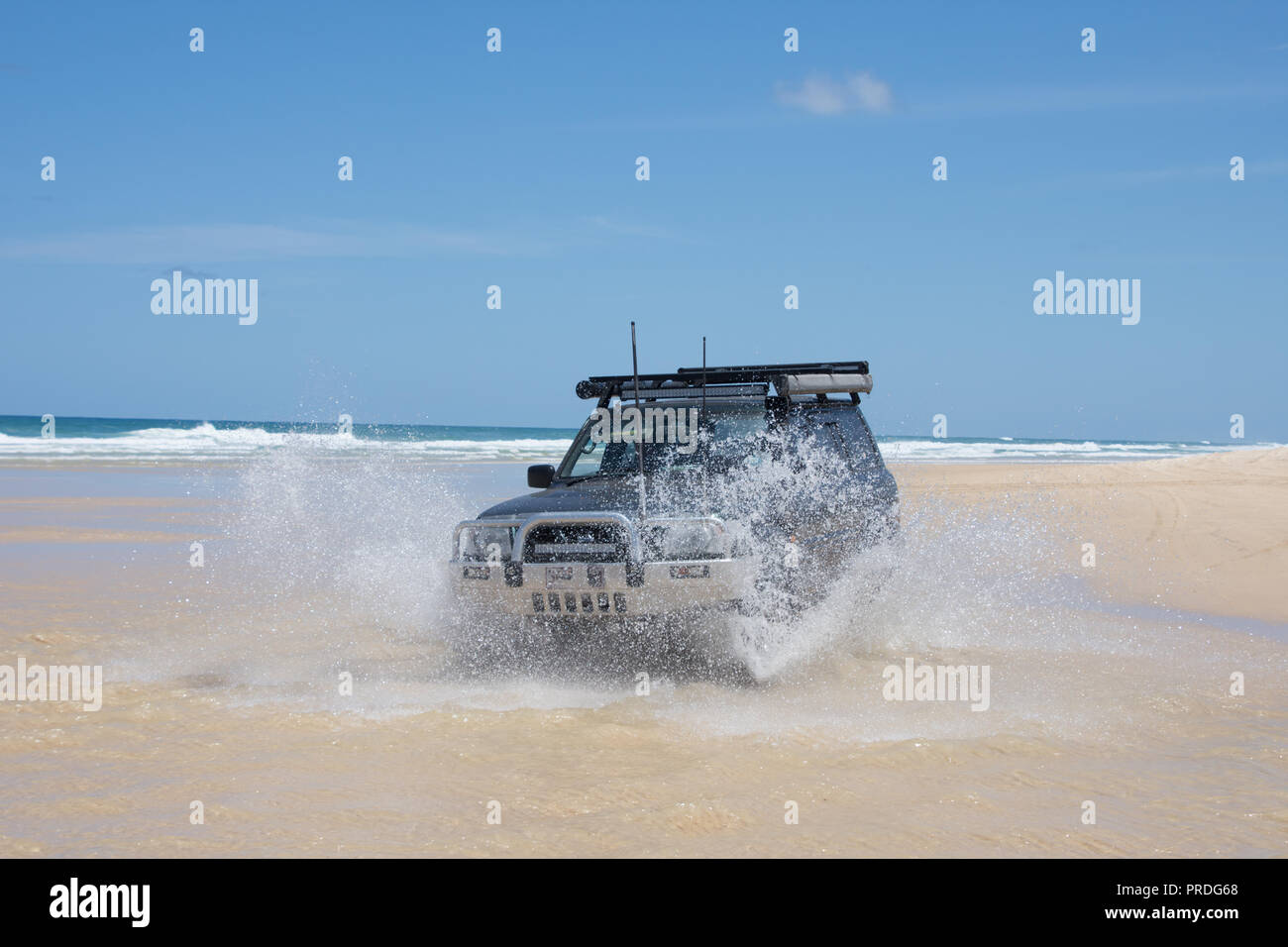 4WD Auto Fluß am Strand auf Fraser Island, Queensland, Australien an einem sonnigen Tag mit großen Splash Stockfoto