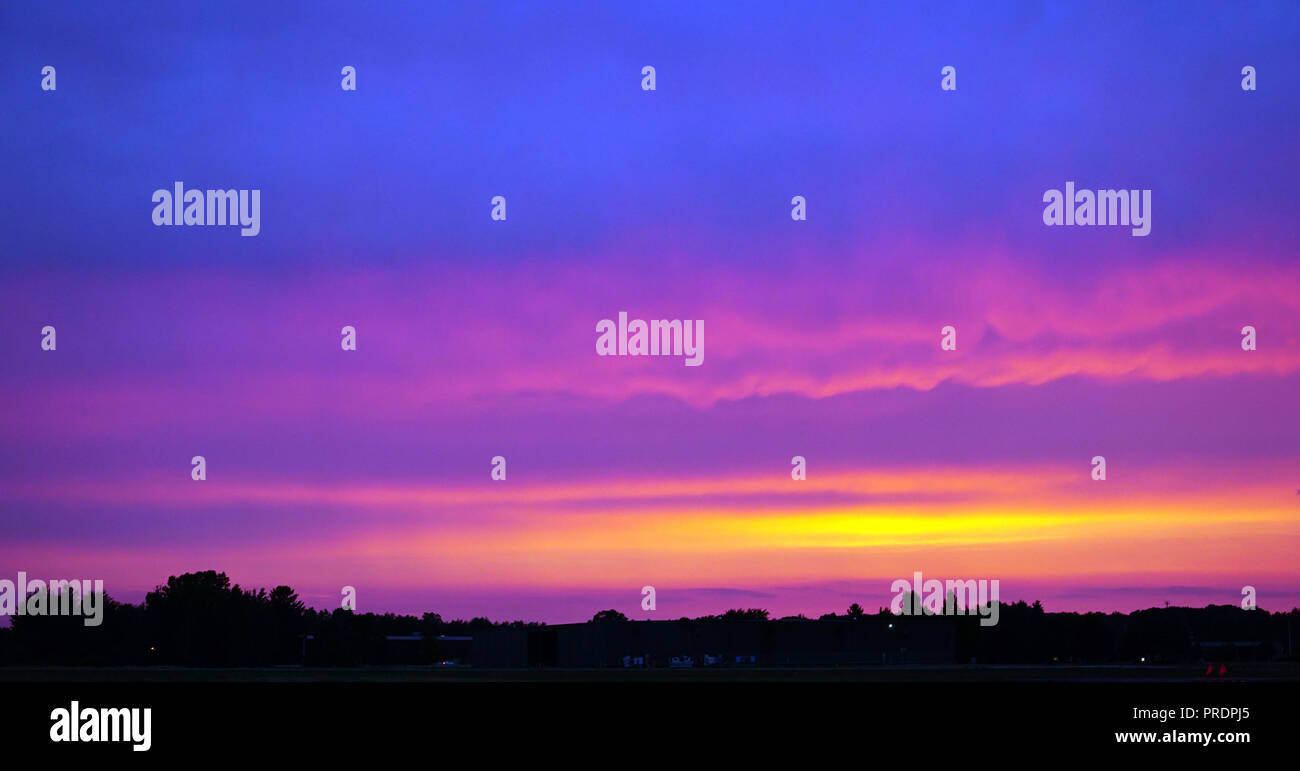 Sanft Rosa & lila Sonnenuntergang über dem Flugplatz. Pastell Farben Blau, Gelb und rosa Wolken. Violette Töne. Stockfoto
