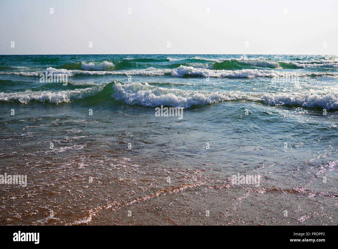 Stürmische See an einem sonnigen windigen Tag. Große Wellen mit weißen Schaum auf dem Kamm steigen über die Oberfläche des Wassers und zum Ufer laufen. Wunderschönes b Stockfoto