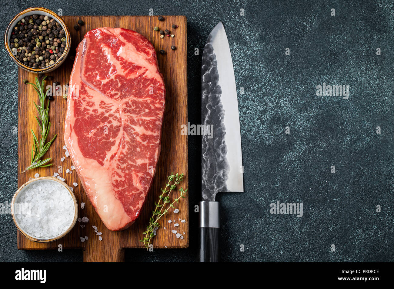 Frische rohe Prime Black Angus Beef Steaks mit Gewürzen auf hölzernen Bo Stockfoto