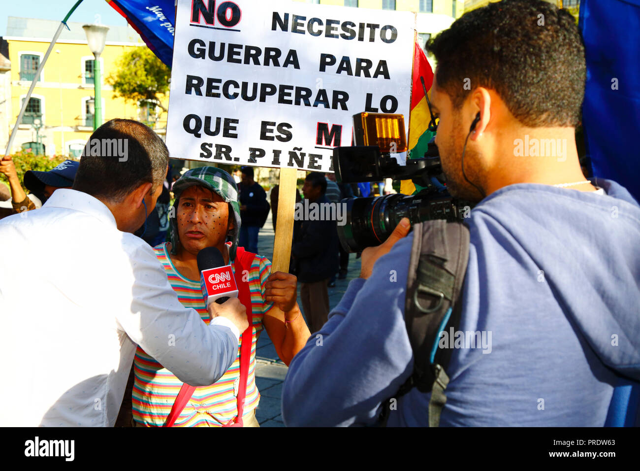 La Paz, Bolivien, 1. Oktober 2018. Ein Mann, der sich als berühmter mexikanischer TV-Charakter El Chavo von der Sitcom El Chavo del Ocho verkleidet hat, spricht vor der Lektüre des Urteils für den Fall "Verpflichtung, den Zugang zum Pazifischen Ozean auszuhandeln" mit einem CNN Chile-Reporter (Bolivien gegen Chile)" am Internationalen Gerichtshof in den Haag. Bolivien stellte den Fall 2013 dem Internationalen Gerichtshof vor; Bolivien verlor seine Provinz Litoral an der Küste während des Pazifikkriegs (1879-1884) an Chile, und frühere Verhandlungen haben aus Boliviens Sicht keine Fortschritte gemacht. Kredit: James Brunker/Alamy Live News Stockfoto