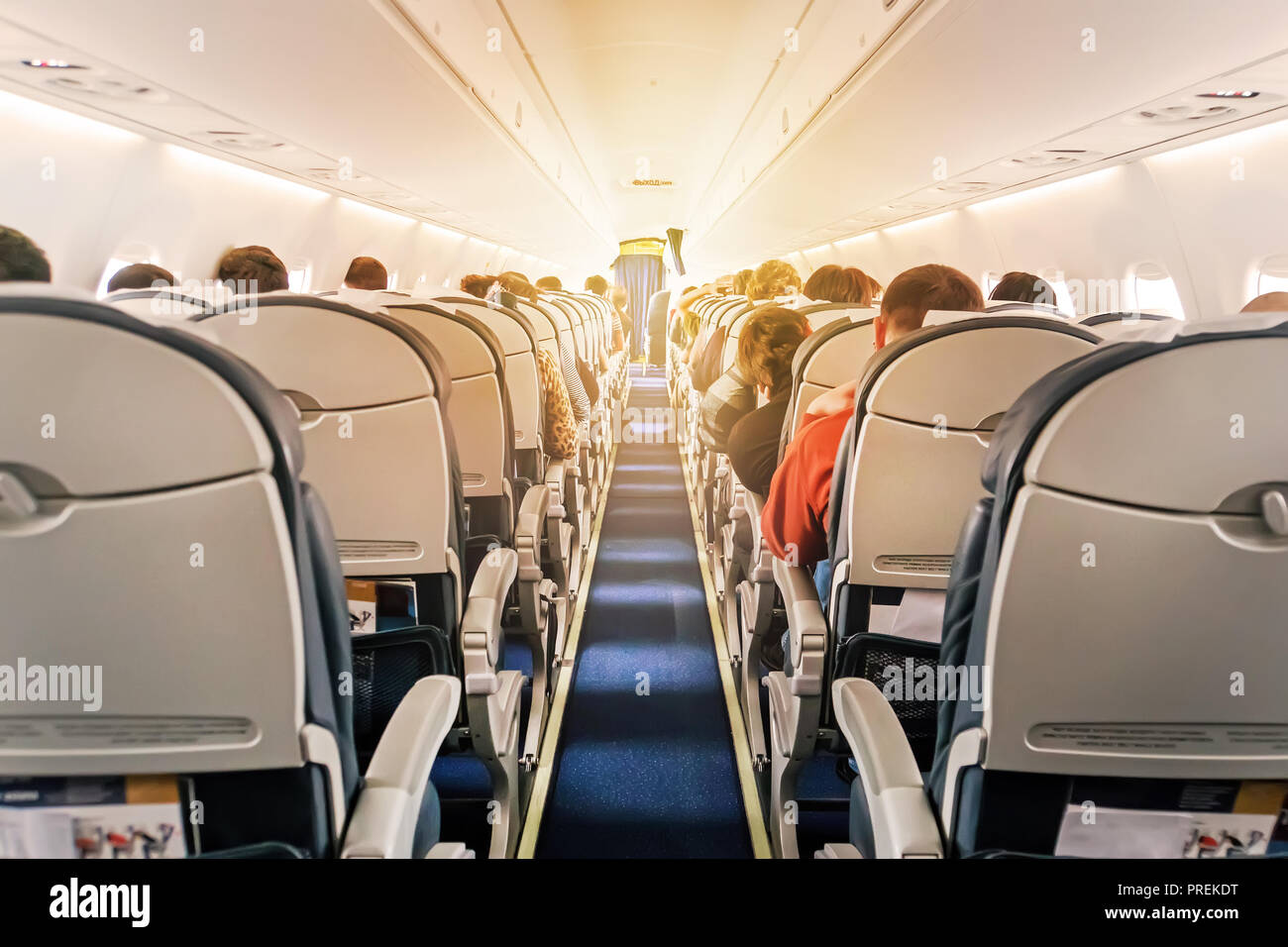Verkehrsflugzeuge Kabine mit Sitzreihen den Gang hinunter. morgen Licht im Salon der Airliner. Economy Class Stockfoto
