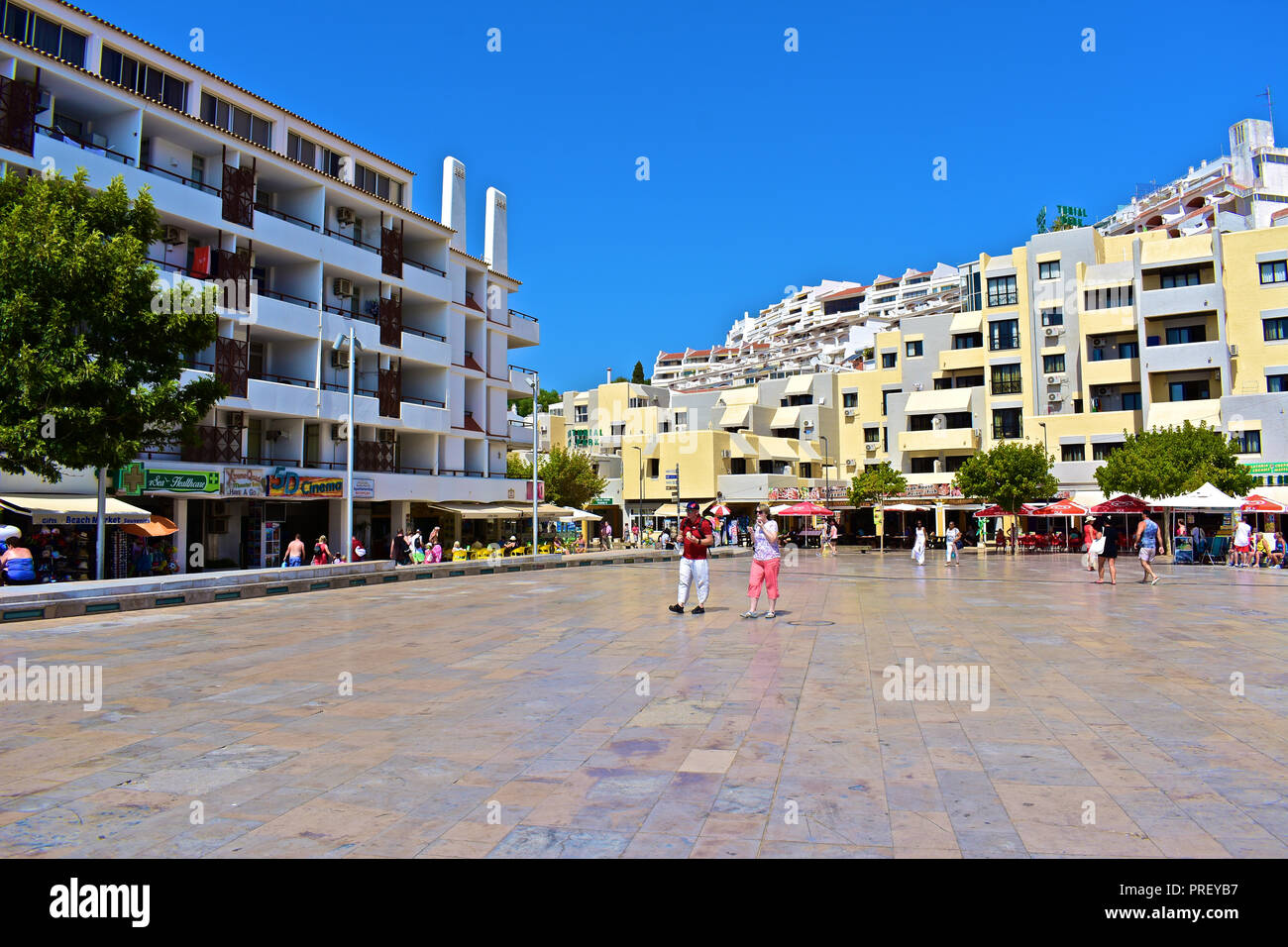 Touristen schlendern über Square dos Pesdores - einer modernen zentralen Platz im Herzen der Altstadt von Albufeira, die zum Strand führt. Algarve, Portugal Stockfoto