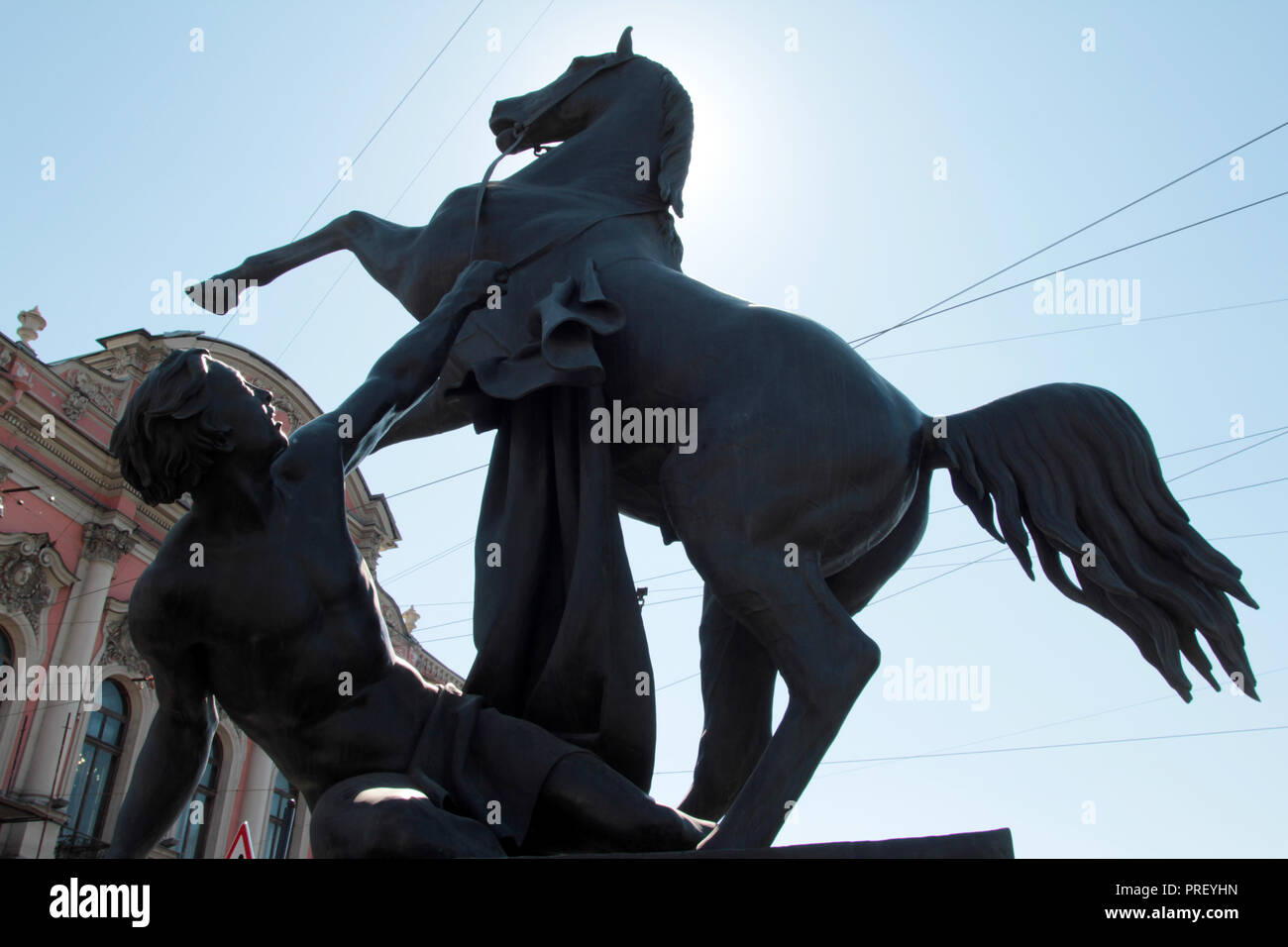 Auf der Anitschkow-brücke, das ist auf dem Newski Prospekt, es gibt vier dynamische Statuen wie die Zähmung des Pferdes oder das Pferd Dompteure bekannt, und es gibt eine an jeder der vier Ecken der Brücke in St. Petersburg, Russland. Sie sind auffällig, Blickfang und wunderbar auf ihren Sockeln. Stockfoto