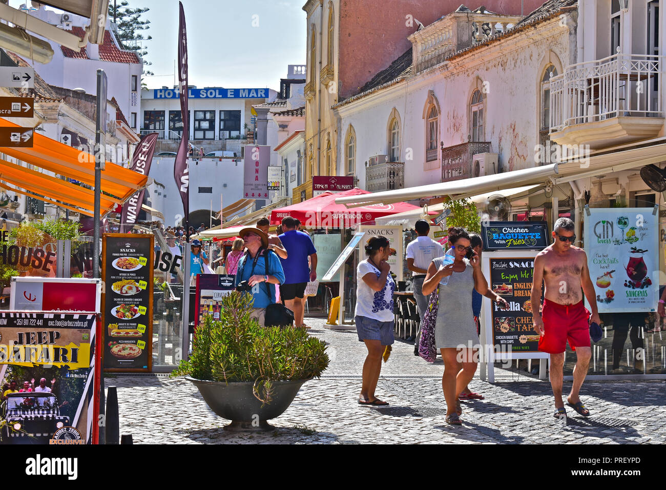 Urlaubern und Touristen genießen den Sommer Sonne wandern über die Straßen der Altstadt von Albufeira, Algarve, Portugal Stockfoto