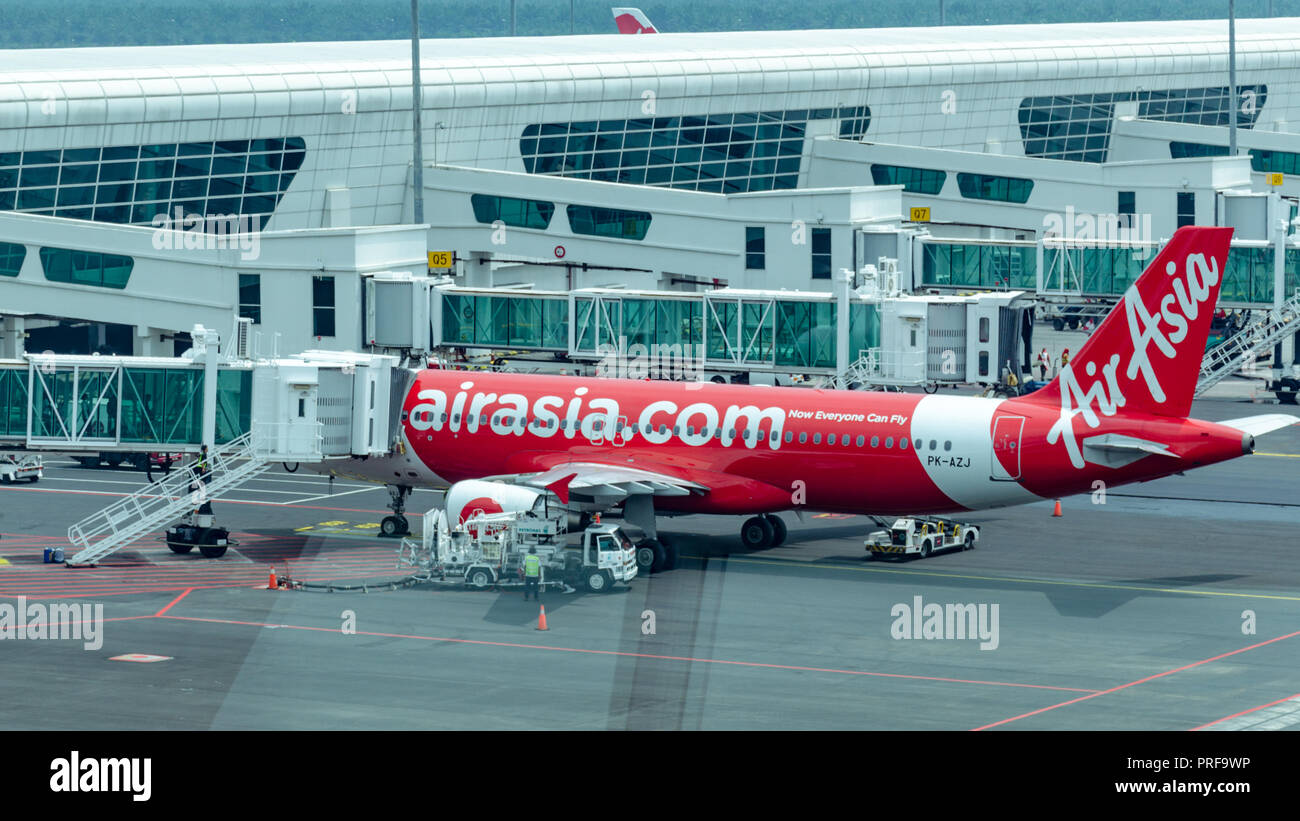 Malaysia, Kuala Lumpur International Airport, 04-03-2018: Flugzeug von Unternehmen Airasia Vorbereitung für den Abflug, Jet Bridge mit Passagieren, Betankung Stockfoto