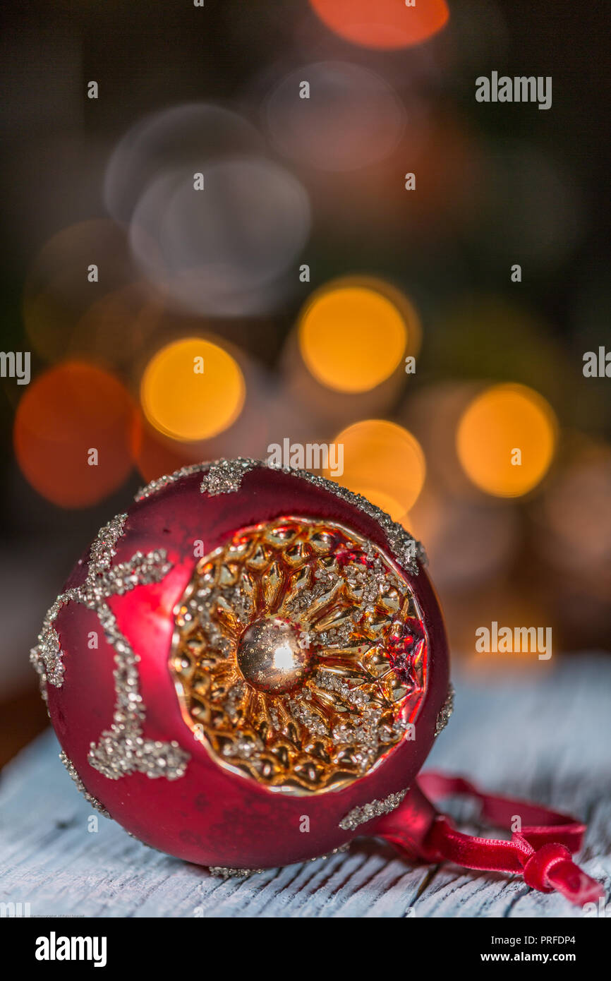 Single Weihnachtskugel auf Holztisch und elektrische Lampen Hintergrund Stockfoto