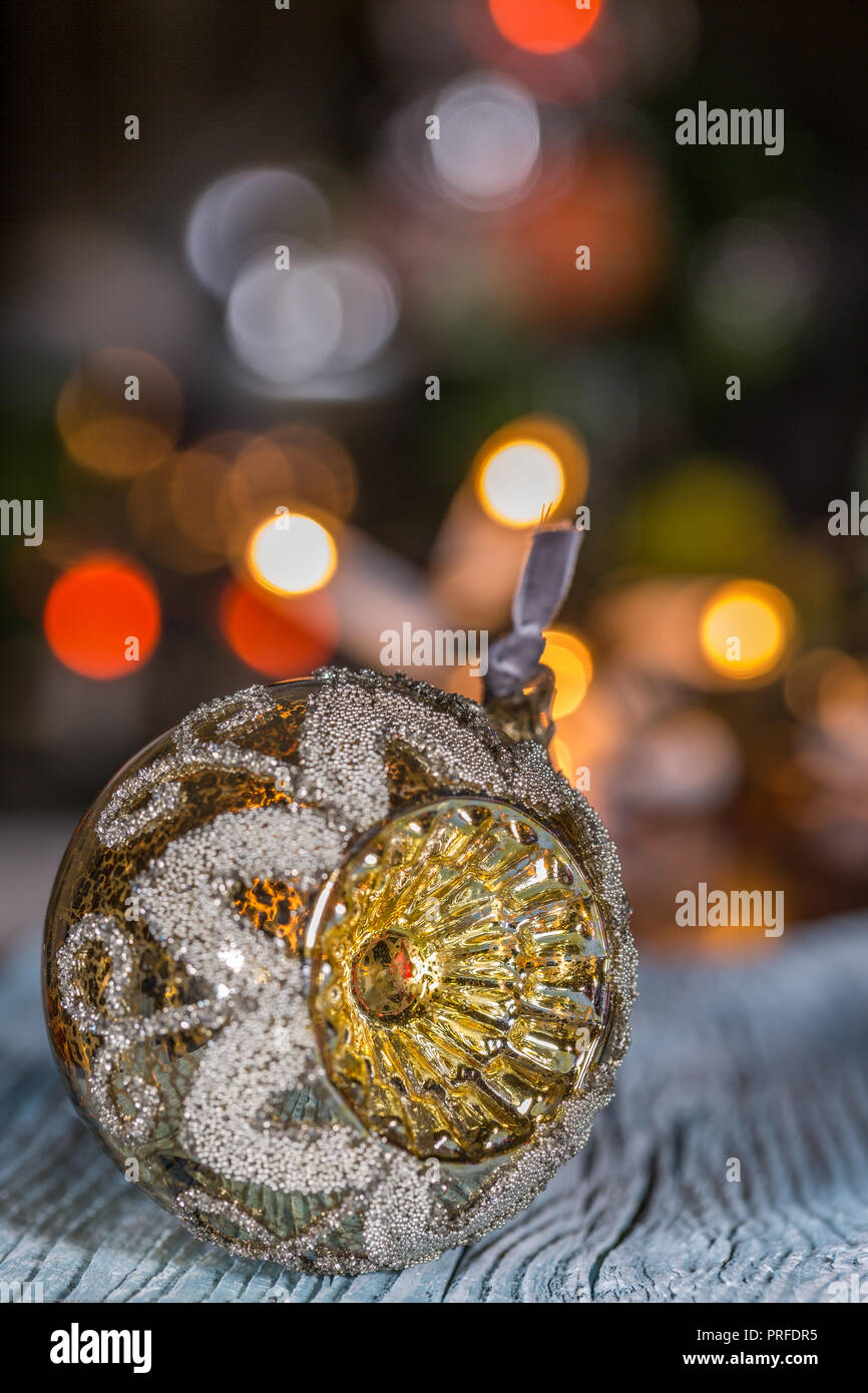 Eine Weihnachtskugel auf Holztisch und elektrische Lampen Hintergrund Stockfoto