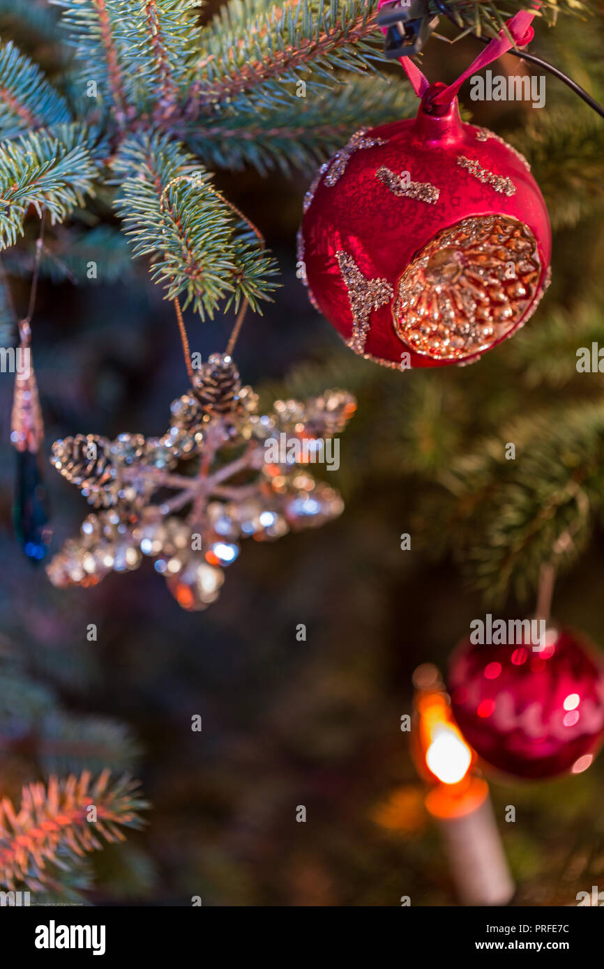 Christbaumkugeln auf Spruce Tree Branch und Lichter Hintergrund Stockfoto