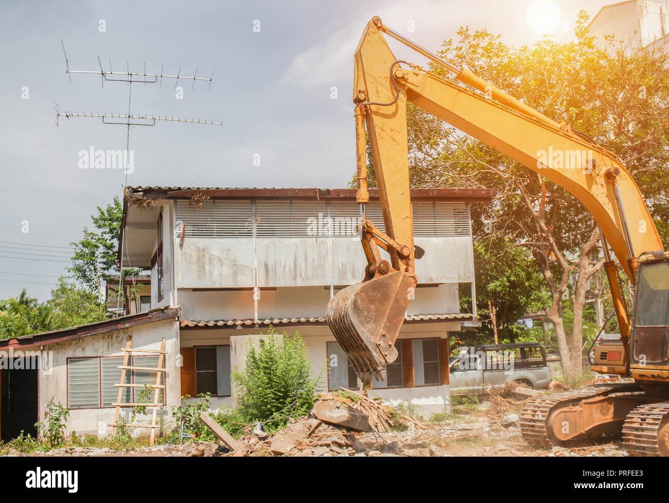 Schaufel bagger Zerstörung in Arbeit im Freien Konstruktion mit Sonnenuntergang licht Ton Stockfoto