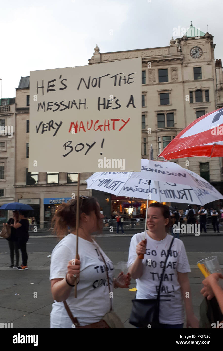 London, GB, 13. Juli 2018. 100.000 Menschen protestieren gegen den Besuch des US-Präsidenten Donald Trump. Die Demonstranten versammeln sich auf dem Trafalgar Square. Eine Frau hält einen placade mit einer Nachricht aus dem Film "Das Leben des Brian", ein anderer hält einen Regenschirm mit eine Nachricht geschrieben. Stockfoto