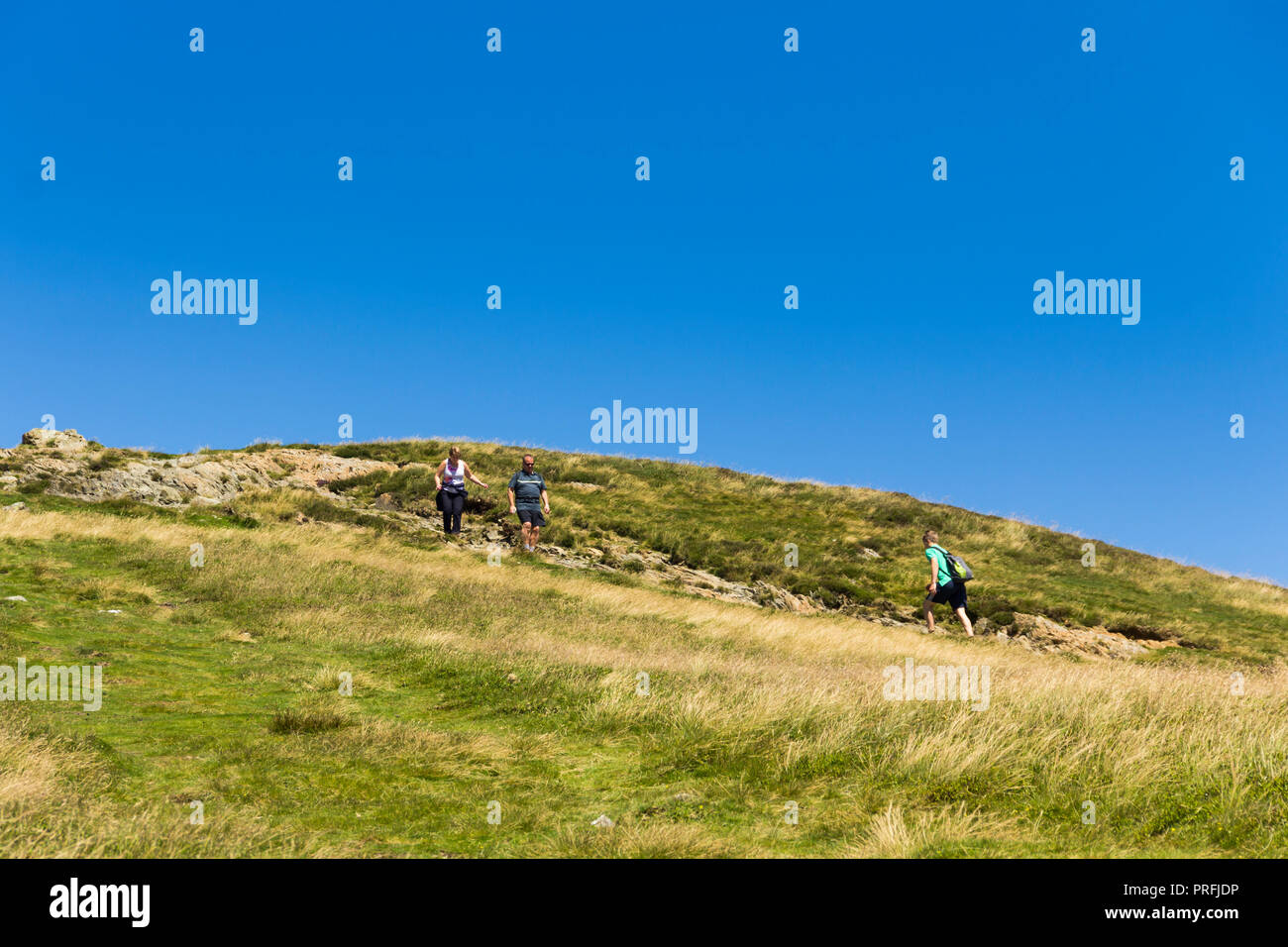 Drei Wanderer nähern sich einander auf den Fußweg Richtung Süden vom Gipfel des Cat Glocken (451 Meter) in der Nähe von Keswick, Cumbria. Stockfoto
