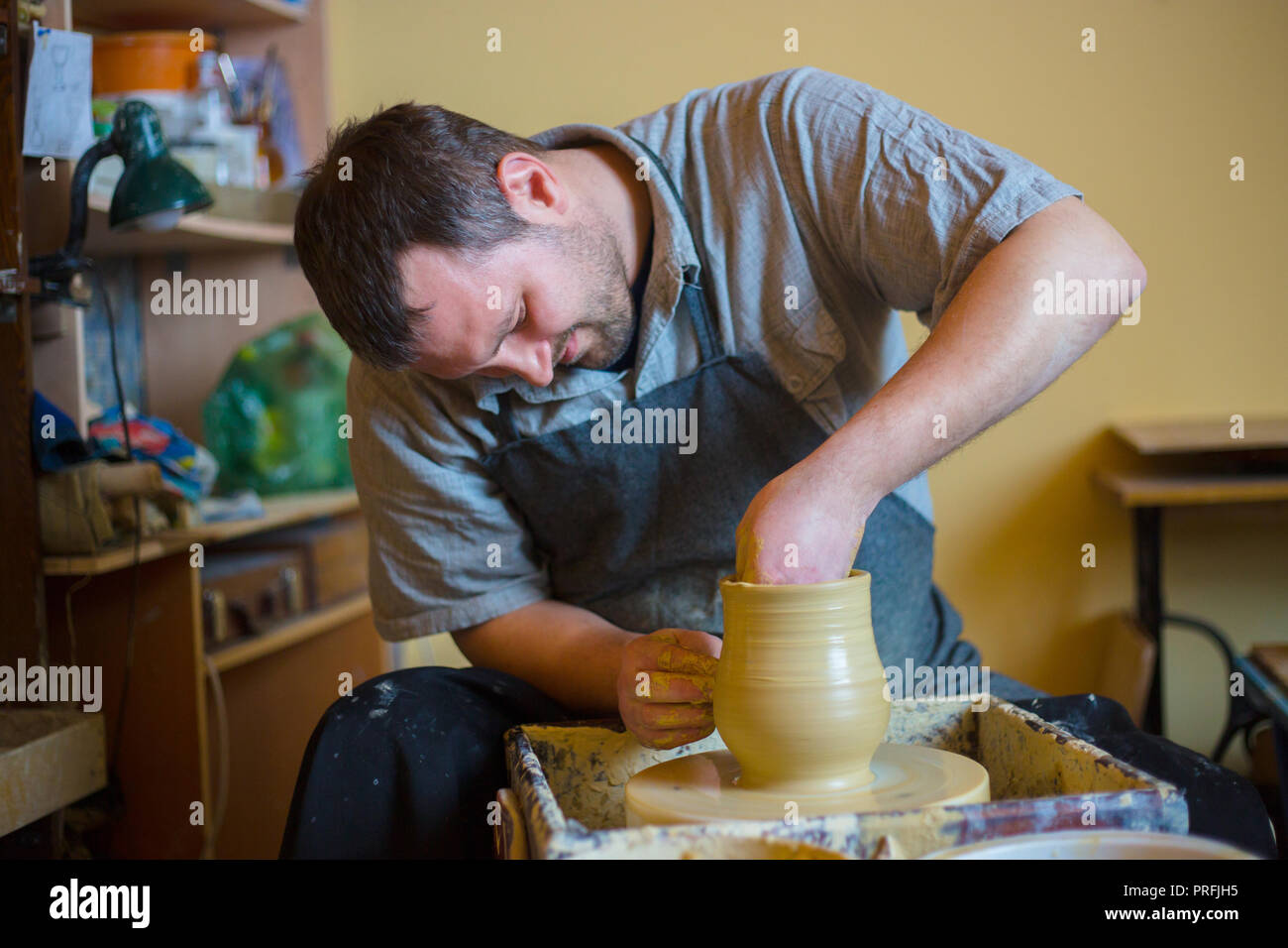 Professionelle männlichen Potter Arbeiten mit Ton auf der Töpferscheibe in Werkstatt, Studio. Handgefertigte, Kunst und Handwerk Konzept Stockfoto