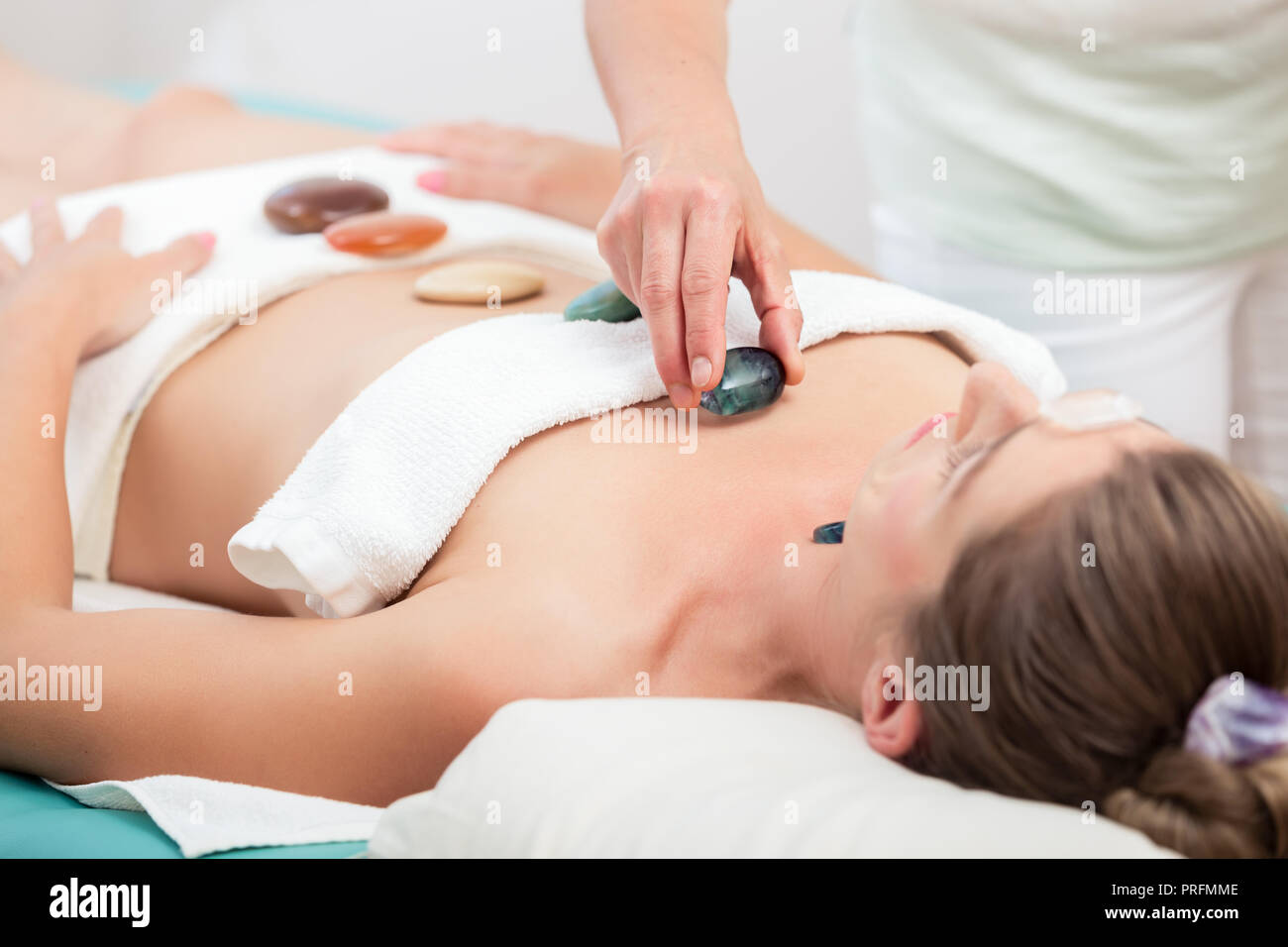 Therapeut sie Steine auf Körper der Frau Stockfoto